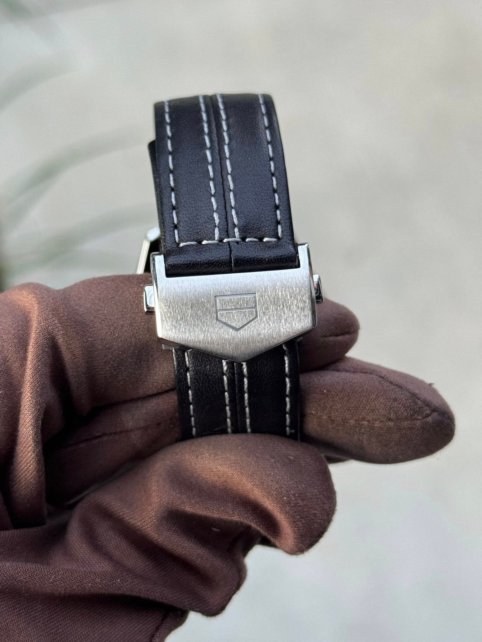 May be an image of saddle-stitched leather and wrist watch