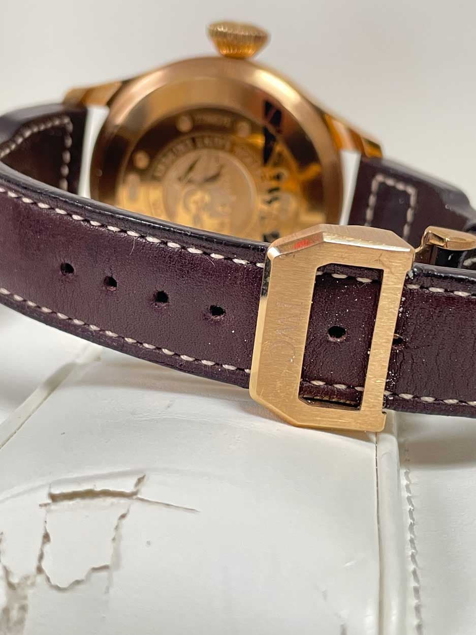 May be an image of wrist watch, leather and text