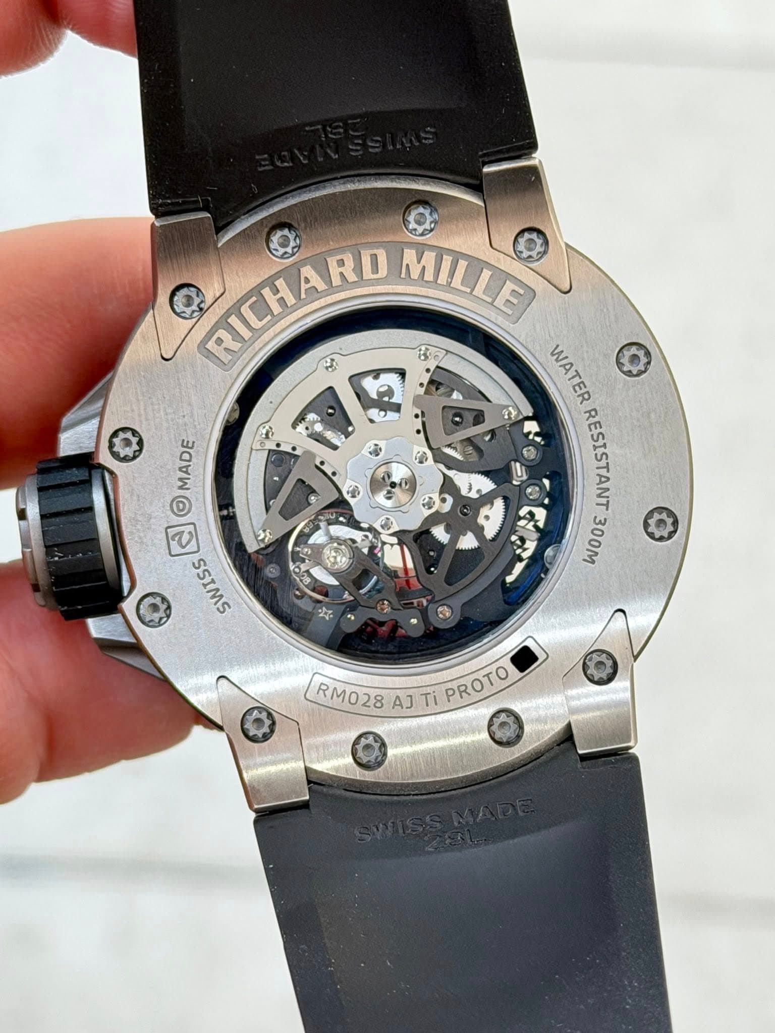 May be an image of wrist watch and text that says 'جم 3 MADE ባ A RICHARD M MILLE Be Q WATER ッ ၁ S SOTTRATOOOOO 100M 300M RESISTANT ၀ ጋዴ ငါ SWISS می RM028 AJ Ti PROTO PROTO'