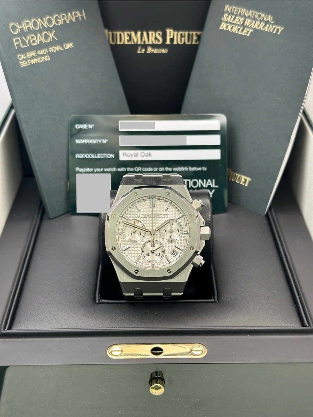May be an image of wrist watch and text that says 'CHRONOGRAPH FLYBACK ROYAL O4 CALIBRE BRE 4401 SELFWINDNG UDEMARS PIGUE LeBrasee Le SALES BOOKLETRANTY WARRANTY NITERNATIONAL…