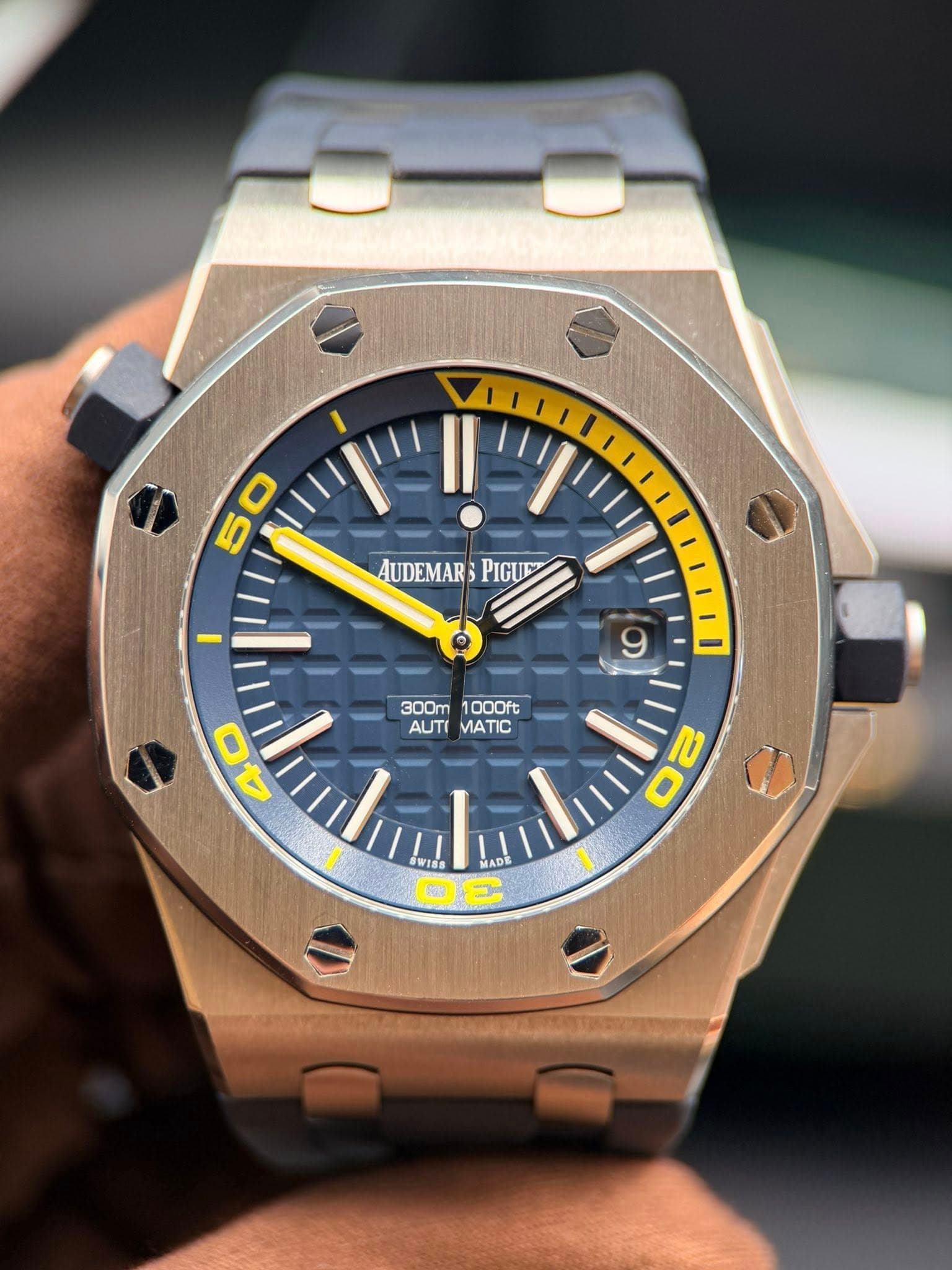 May be an image of wrist watch and text that says '5 50 ٥ 9 AUDEMAR AUDEMARPIGUE PIGUM inua 300m1000ft AUTIMATIC AUTI MATIC 300m 1000ft 40 WIS MADE DE 1 O'