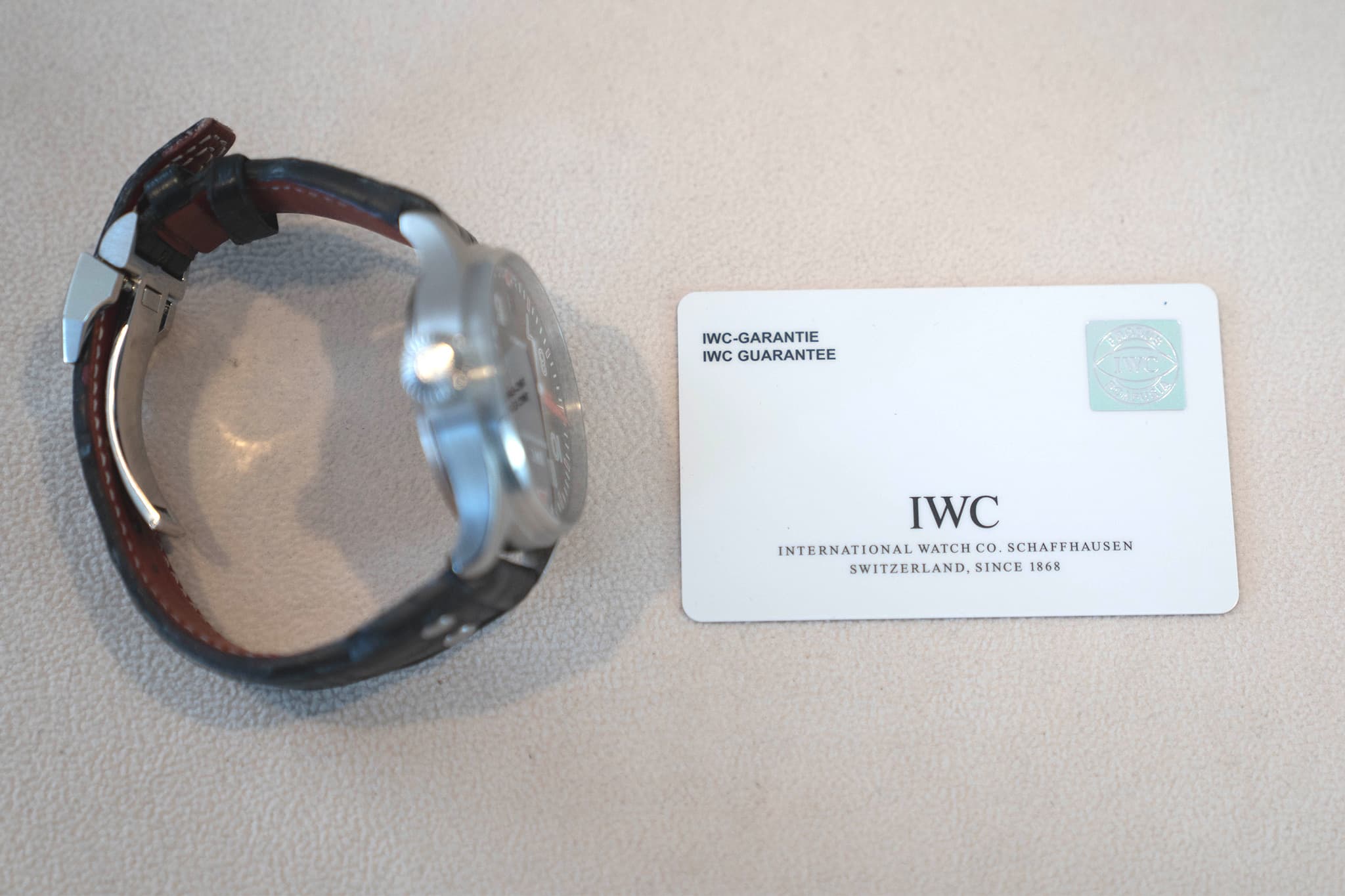 May be an image of digital watch and text that says 'IWC-GARANTIE IWC GUARANTEE 金城 IWC INTERNATIONAL WATCH NTENATIONALWATCH.CO.CHAFHAUSEN co. SCHAFF SCHAFPHAUSEN HAUSEN…
