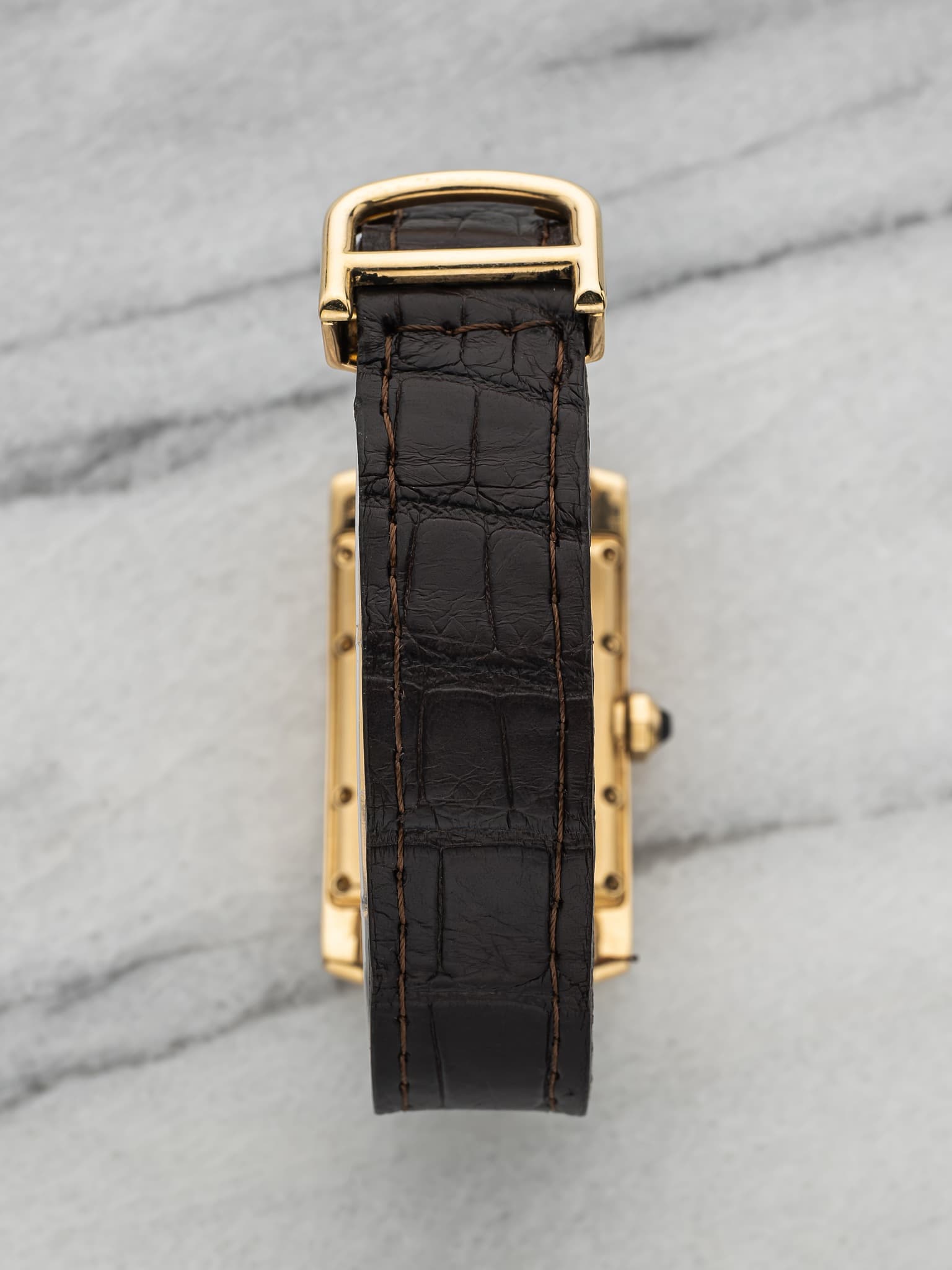May be an image of saddle-stitched leather, leather and wrist watch