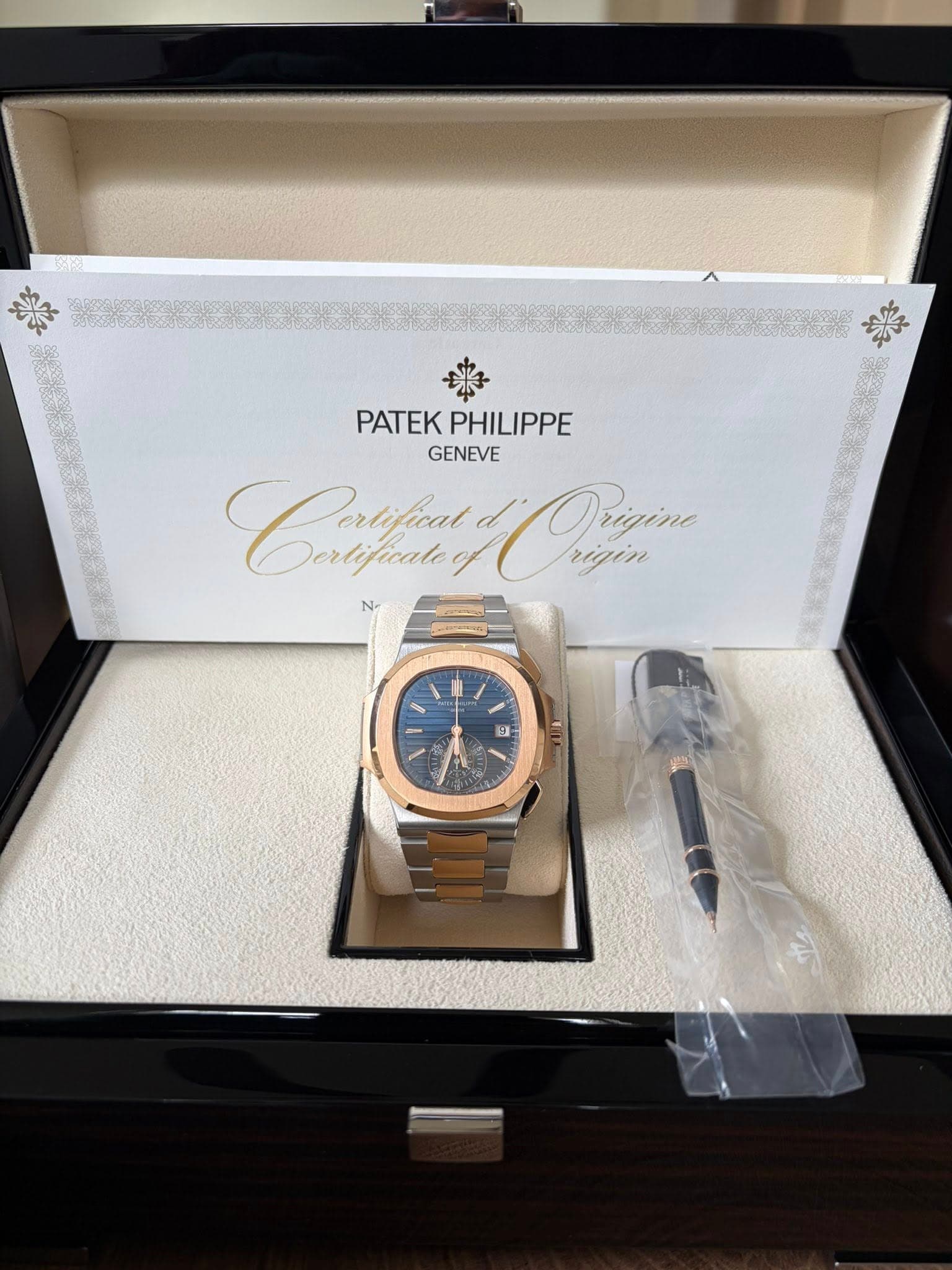 May be an image of wrist watch and text that says 'PATEKPHILIPPE PATEK PHILIPPE GENEVE Cfeny Dertificate Oe rigin rigin Prigine rigine 3'