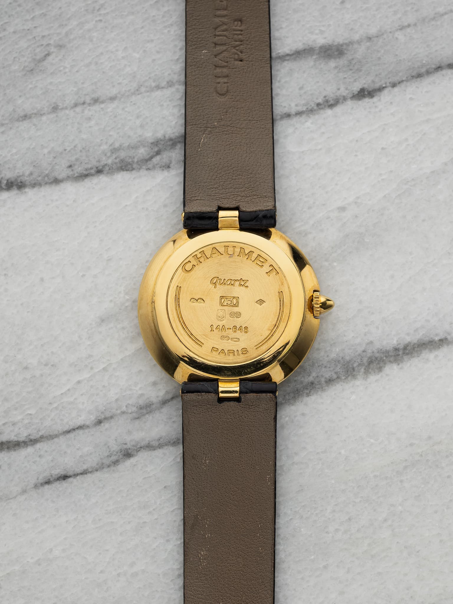 May be an image of wrist watch, leather and text