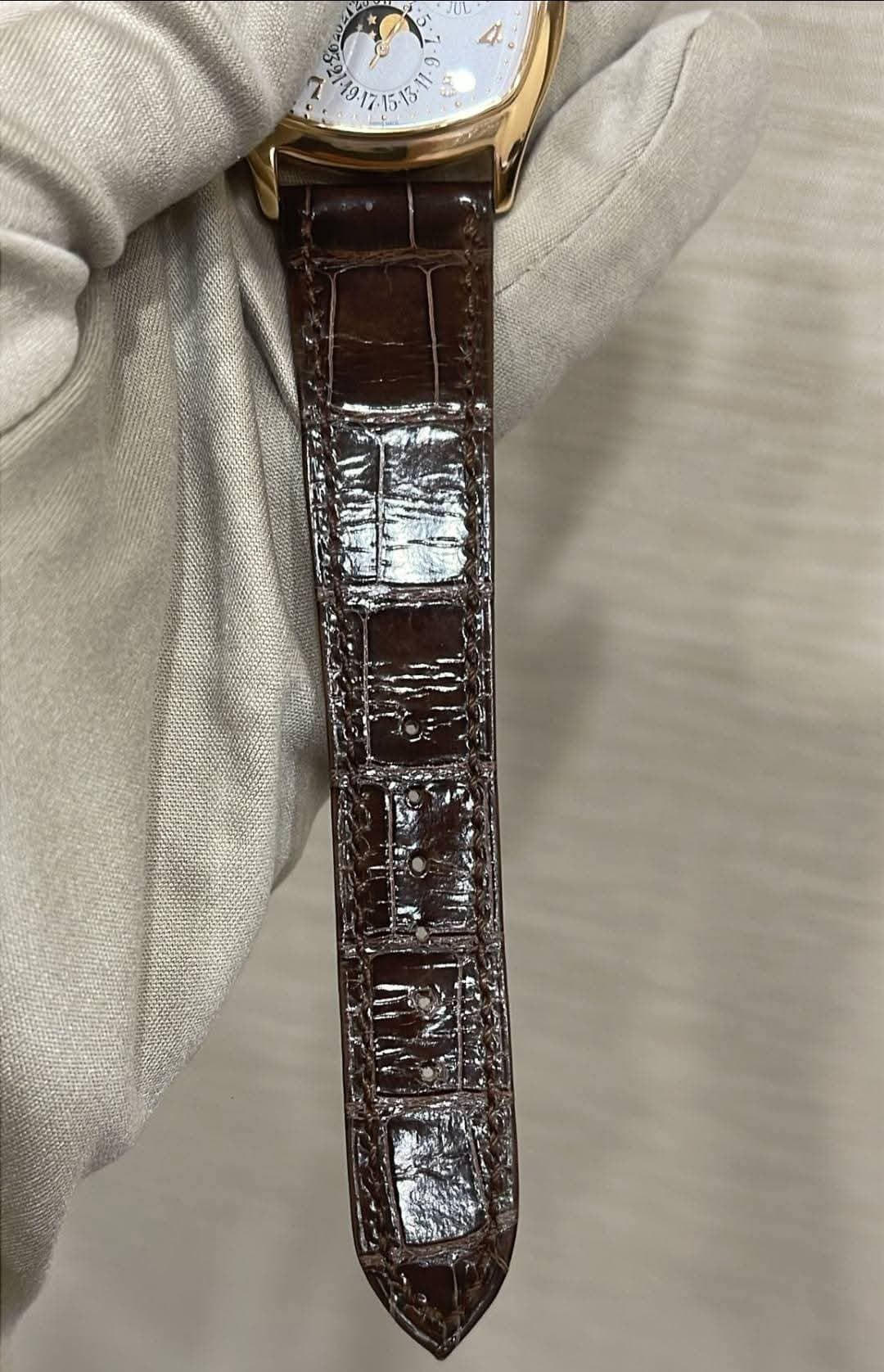 May be an image of wrist watch, leather and text
