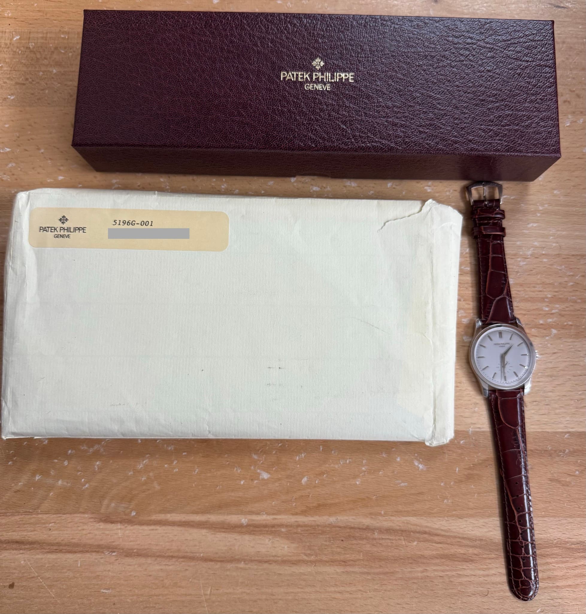 May be an image of leather, wrist watch and text that says 'PATEKPHLIPPE + PATEK PHILIPPE IPPE GENEVE PATEK PATEKPHILIPPE HILIPPE PPE 5196G-001 มั'