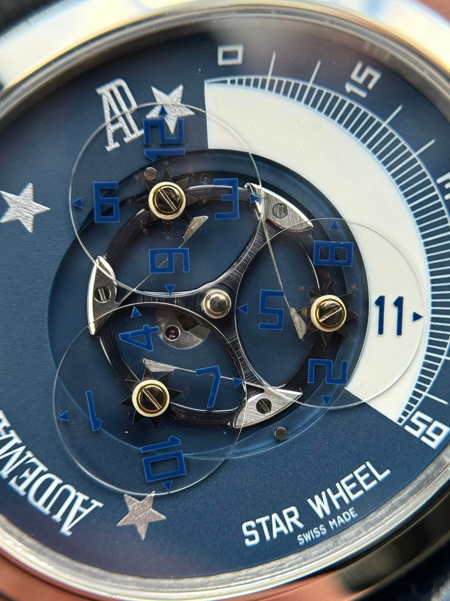 May be an image of wrist watch and text that says 'ਪੁ A* 11 LAANA 59 WHEEL MADE STAR SWISS'