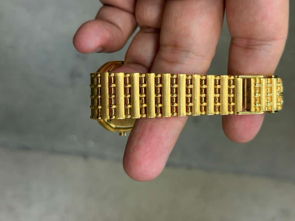 May be an image of digital watch, jewelry and brass