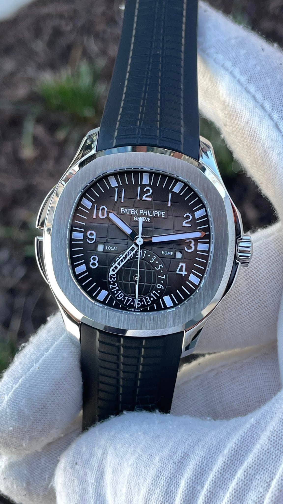 May be an image of wrist watch and text that says ' PATEK PHILIPPE PATEKPHILIPPE IPPE GENEVE 9 HOME 2 3 P LOCAL ب '