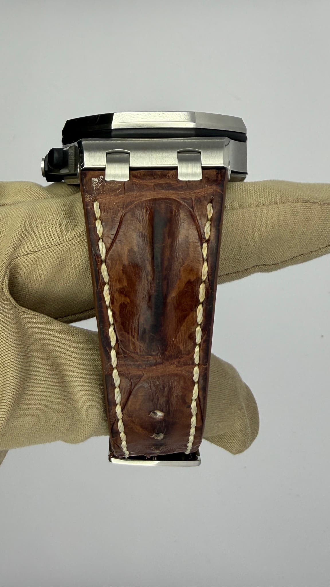 May be an image of saddle-stitched leather, wrist watch, leather and text