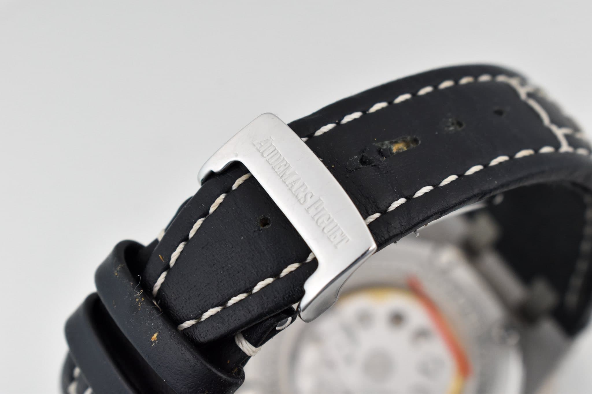 May be an image of wrist watch, leather and text
