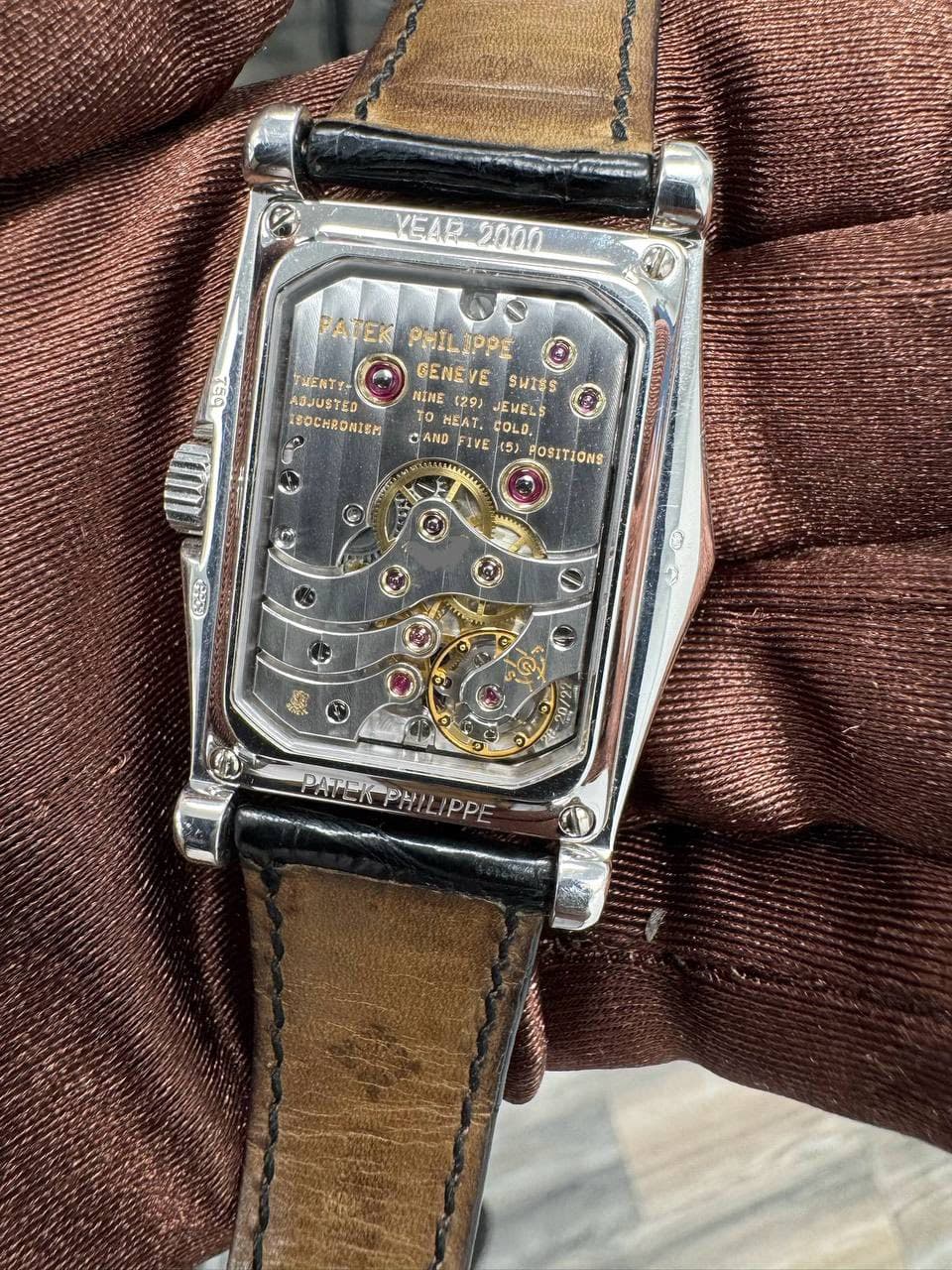 May be an image of wrist watch and text that says 'YEAR YEA2000 2000 PATEK ATEKPHILIPPE APPE pe PHIL TUENTY- GENEVE VE SWISS ADJUSTED NINE (29) JEMELS 1SOCHRONIEM MEAT. COLO. CAND…