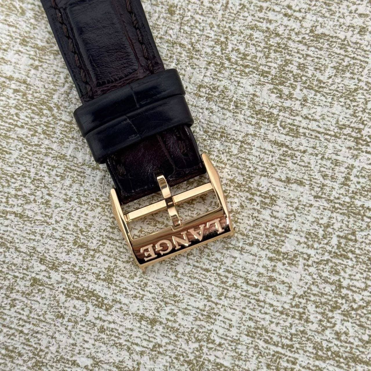 May be an image of saddle-stitched leather, wrist watch and leather