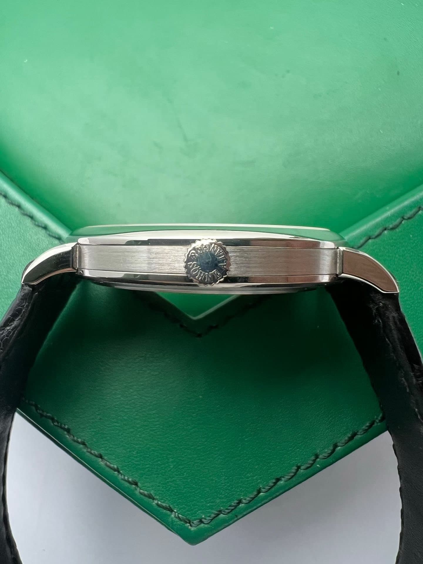 May be an image of saddle-stitched leather, wrist watch and ring