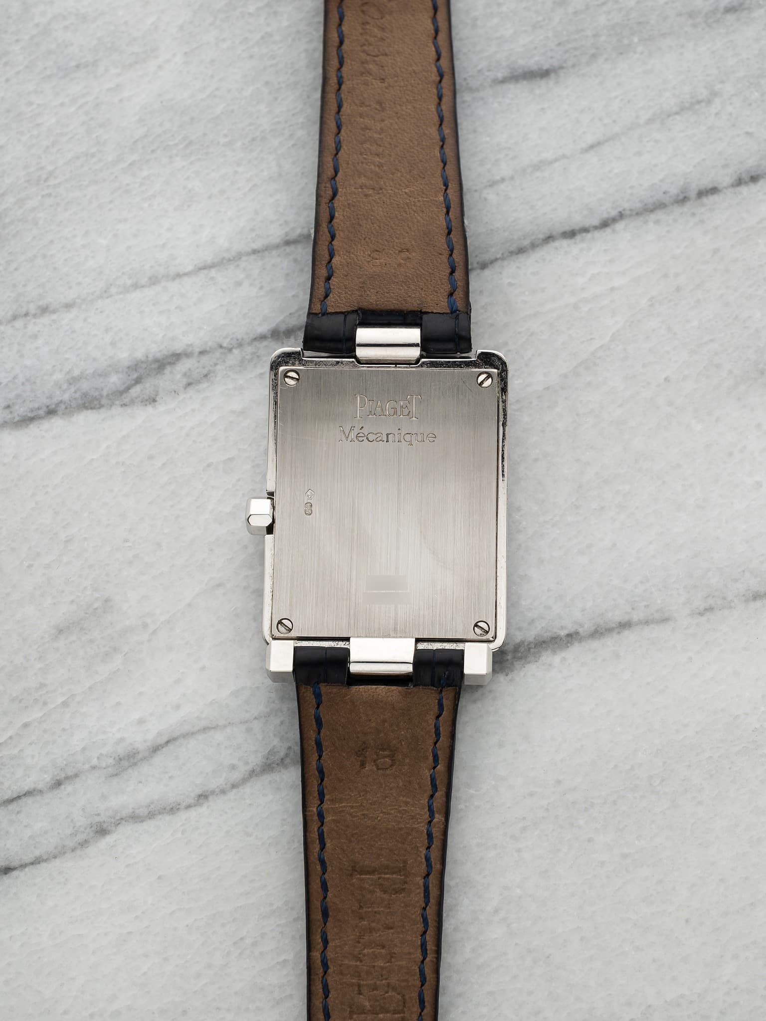 May be an image of wrist watch, leather and text