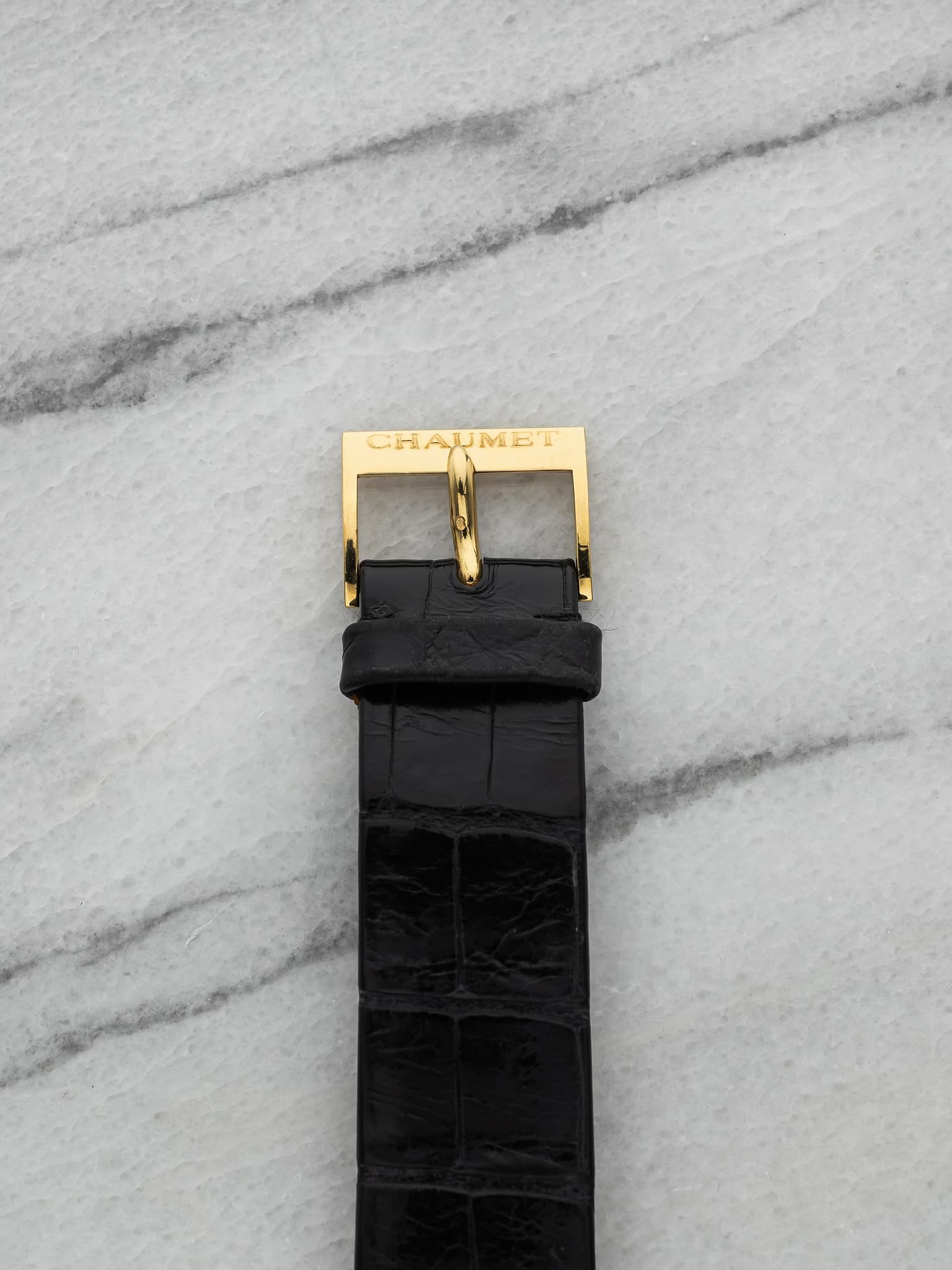 May be an image of saddle-stitched leather, leather, wrist watch and text that says 'CHAUMET อ'