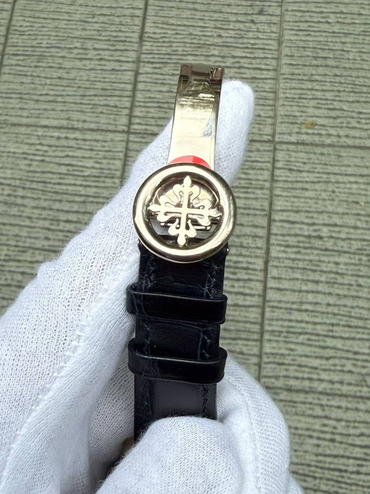 May be an image of wrist watch, leather and text that says '華'