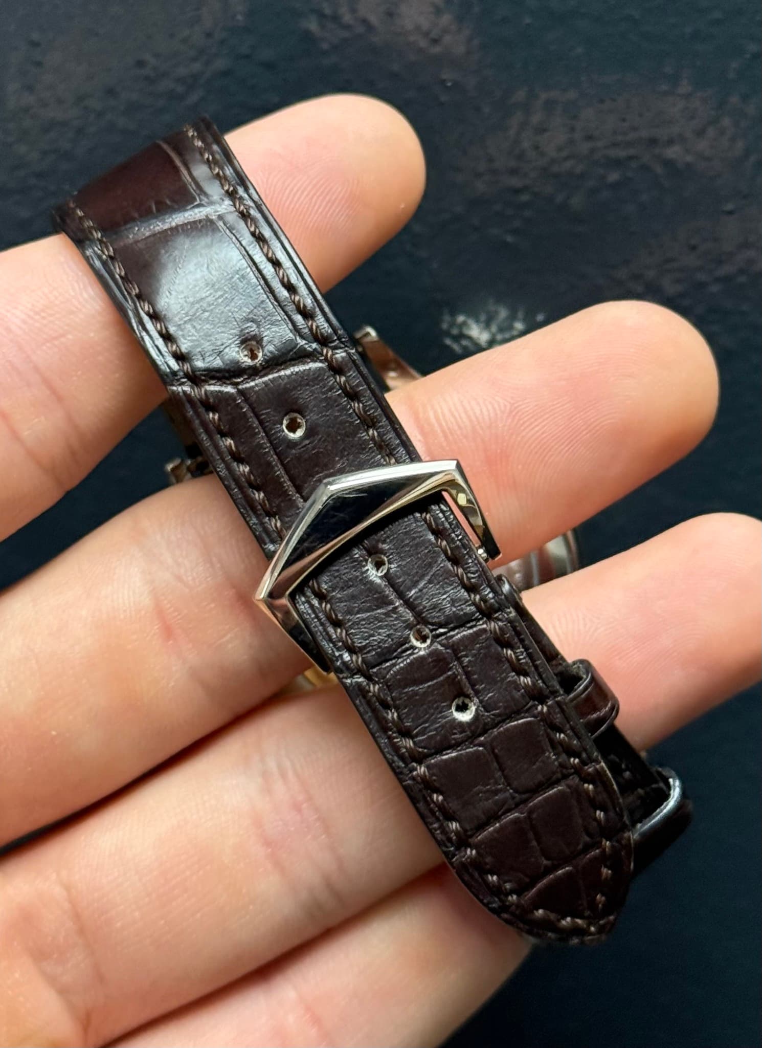 May be an image of saddle-stitched leather, wrist watch and leather