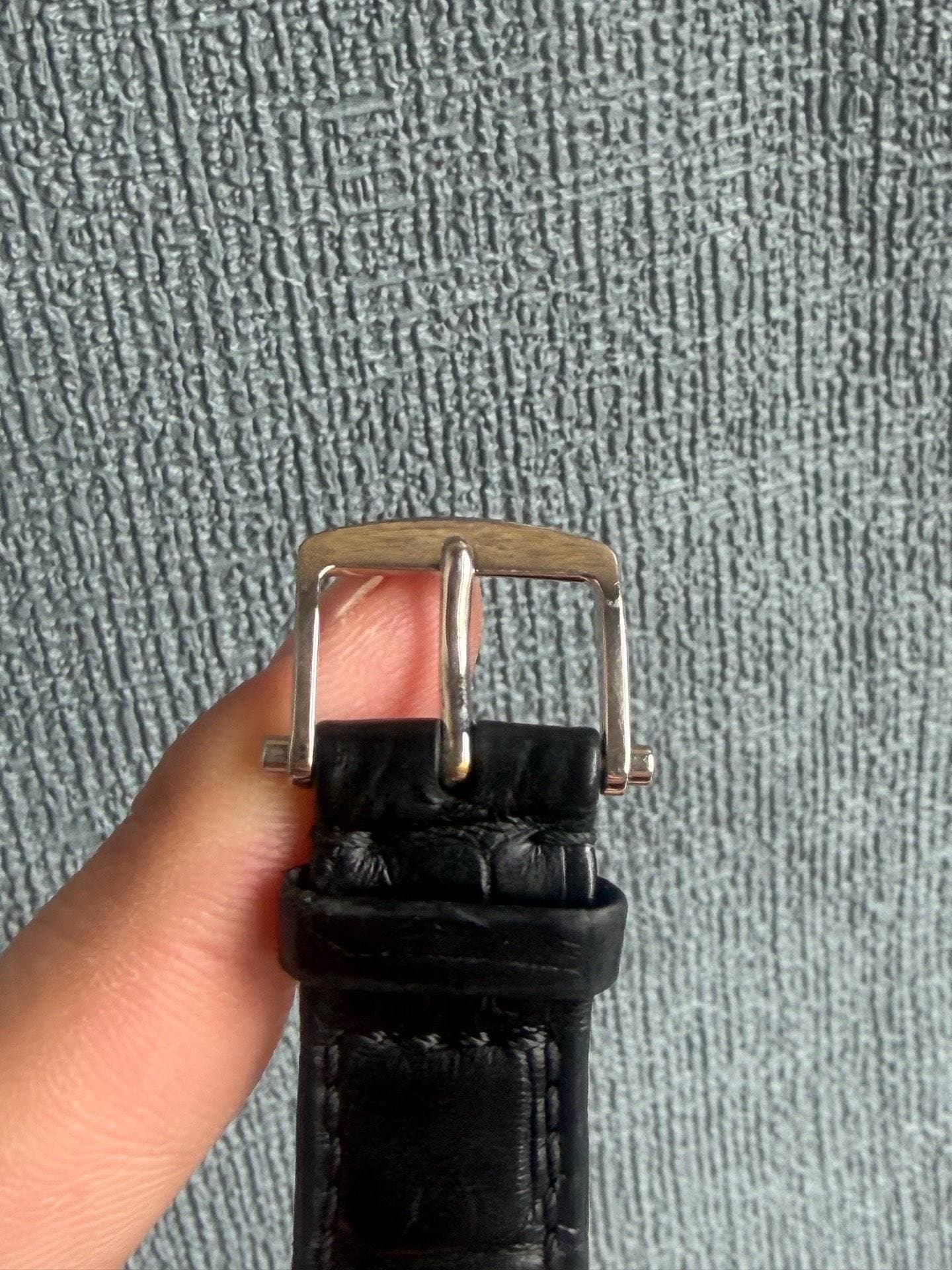 May be an image of wrist watch and saddle-stitched leather