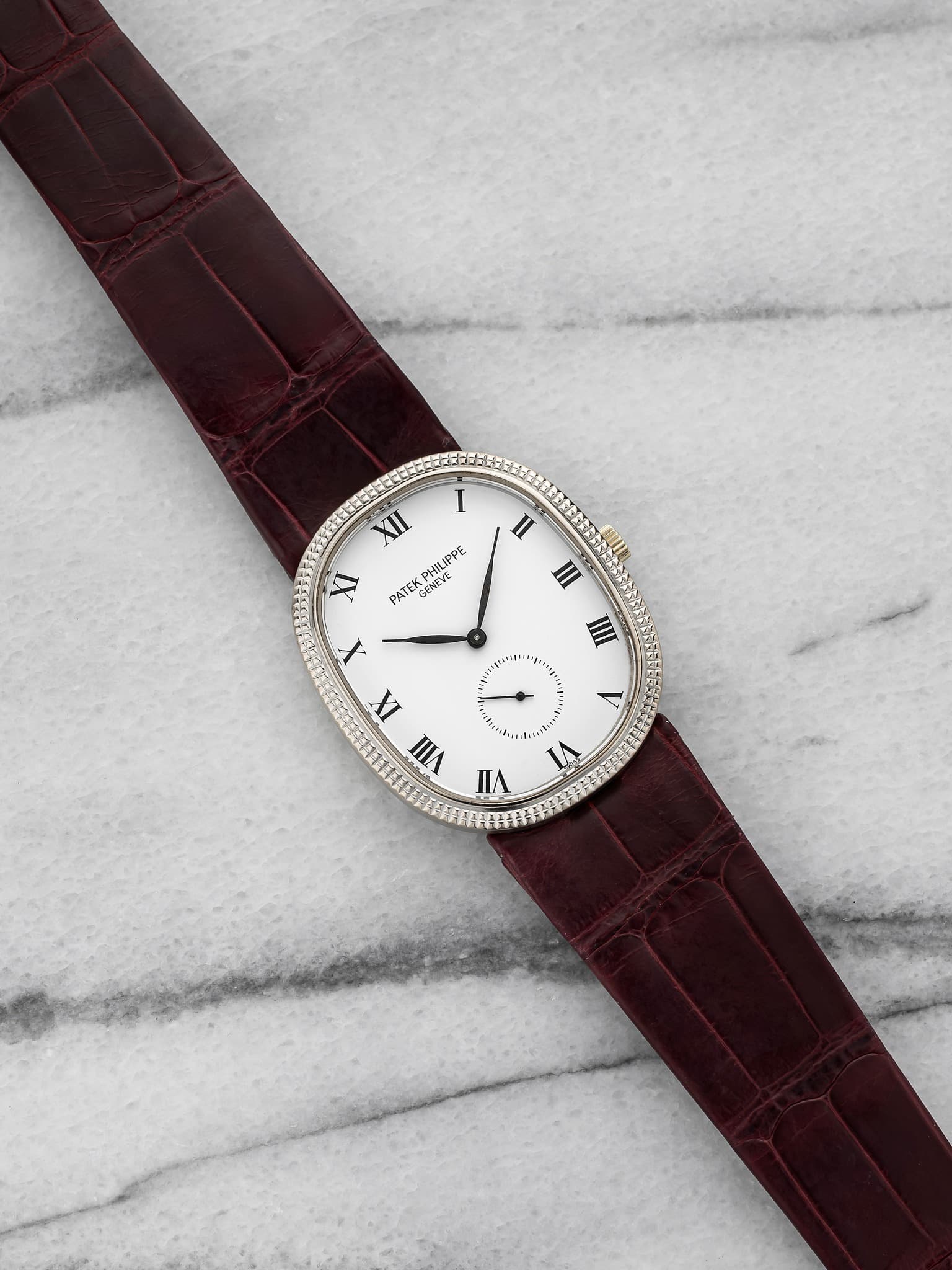 May be an image of leather, wrist watch and text that says 'II II II XII ር I PATEK GENEVE PHA6PΕ SNEVE X IX VIII IA A ミ И'