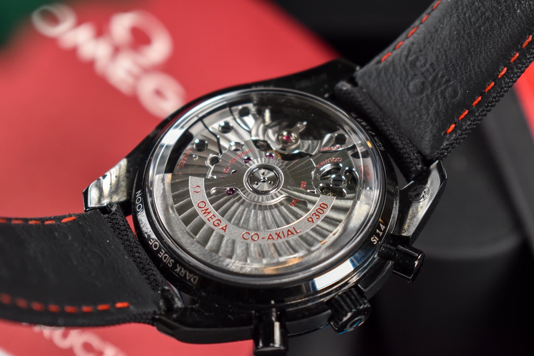 May be an image of wrist watch and text that says 'O U OMEGA ٢٥ AX E 産 9300 CO-AXIAL AXIAL XIAL Si'