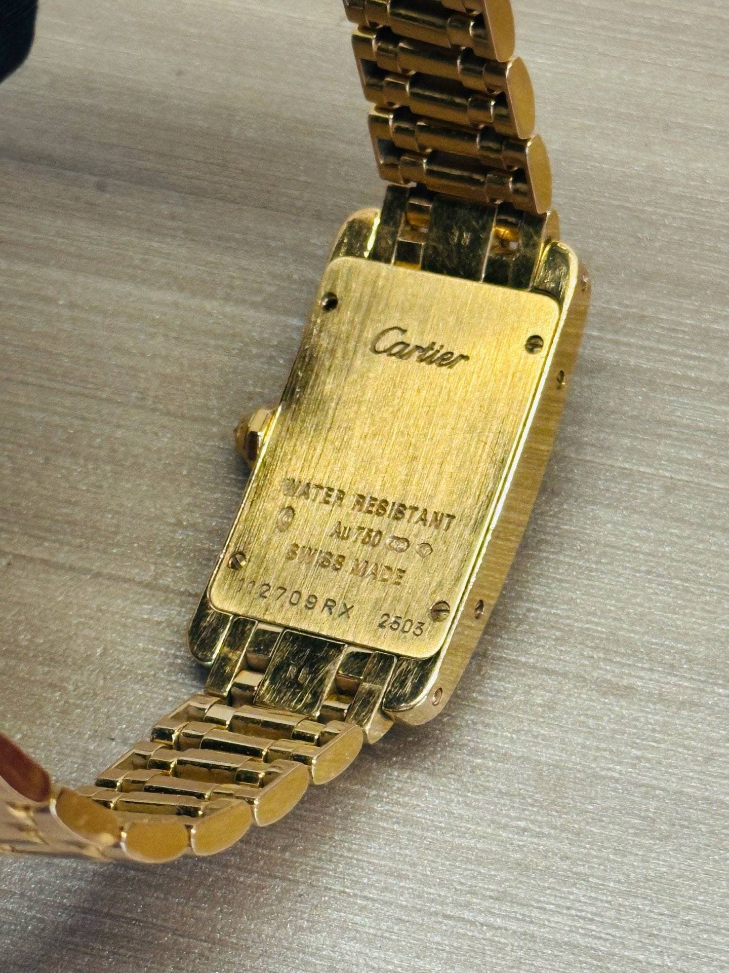 May be an image of digital watch, jewelry and text that says 'ش Cartier yATEЙ RESISTANT 760 υ Byc JASY Ap760tka ABI O MISSMADE 2709RX 2503'