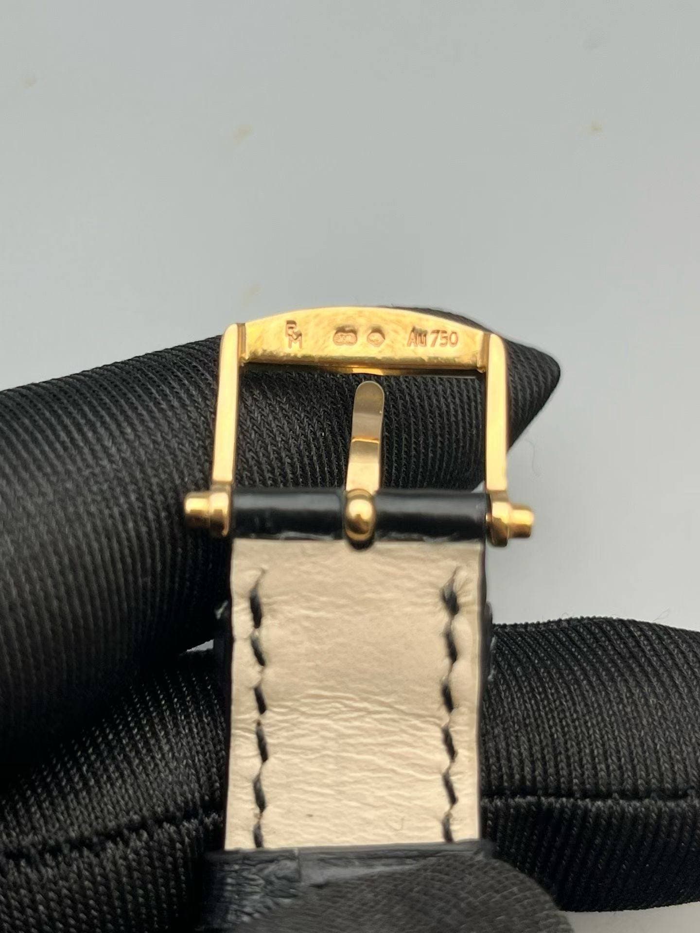 May be an image of saddle-stitched leather, wrist watch and leather