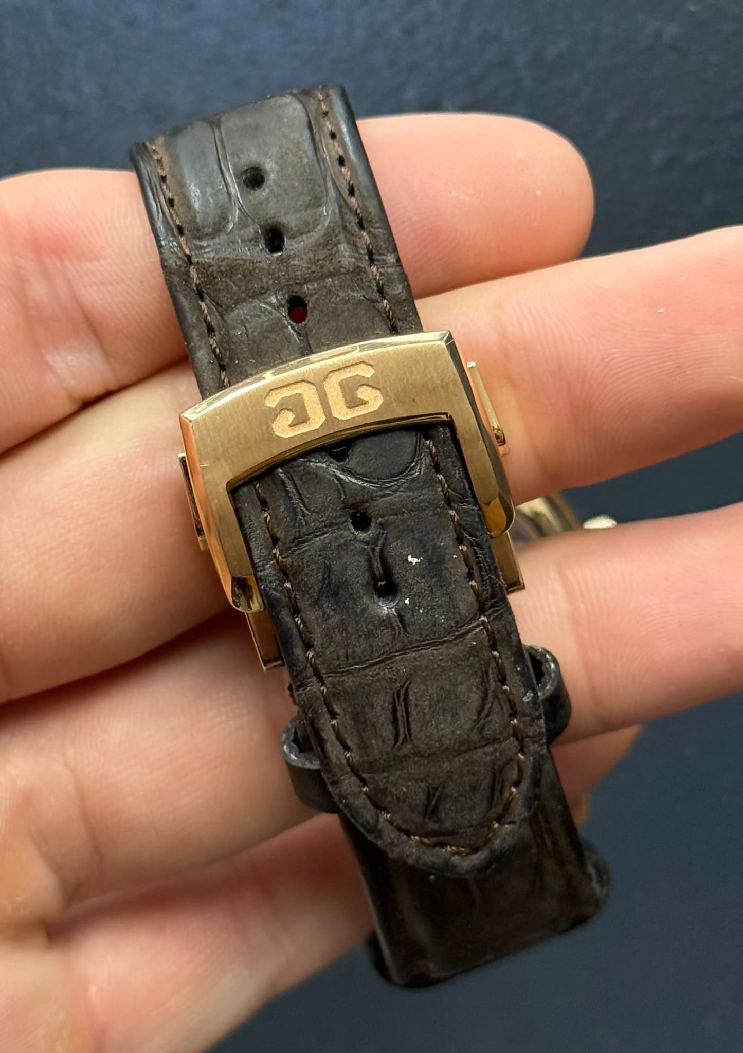 May be an image of leather, wrist watch, saddle-stitched leather and text