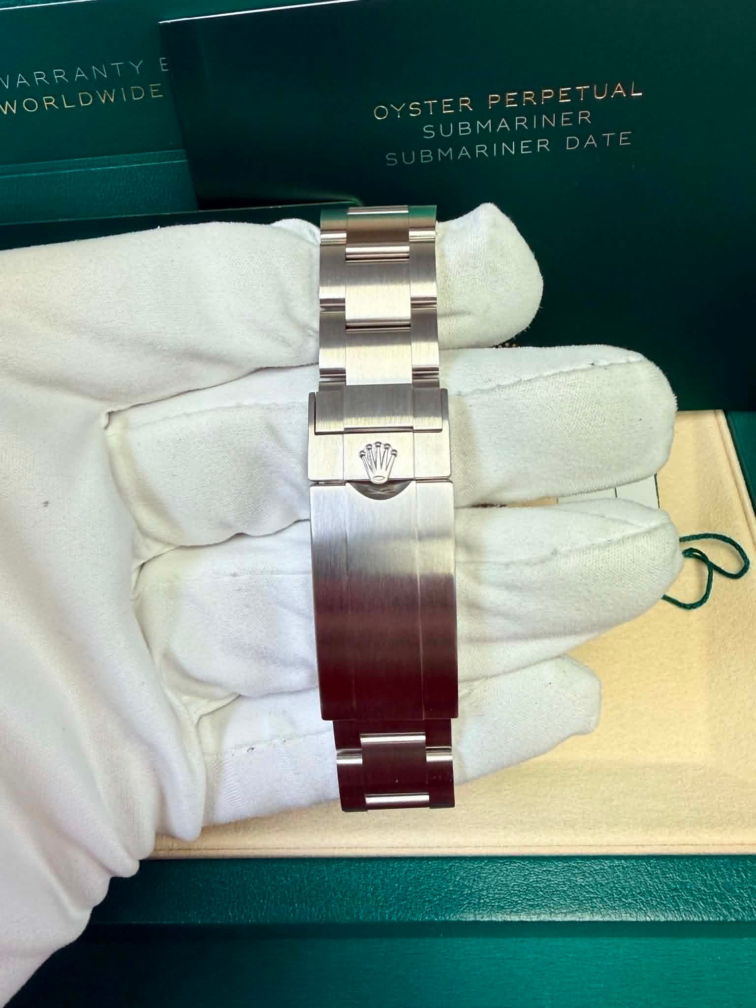 May be an image of wrist watch and text that says 'ARRANTY R WORLDWIDE PERPETUAL OYSTER OYSTERPERPETUAL OYSSUBMARINER DATE SUBMARINER BMARINER BMARINERDATE BMARI'