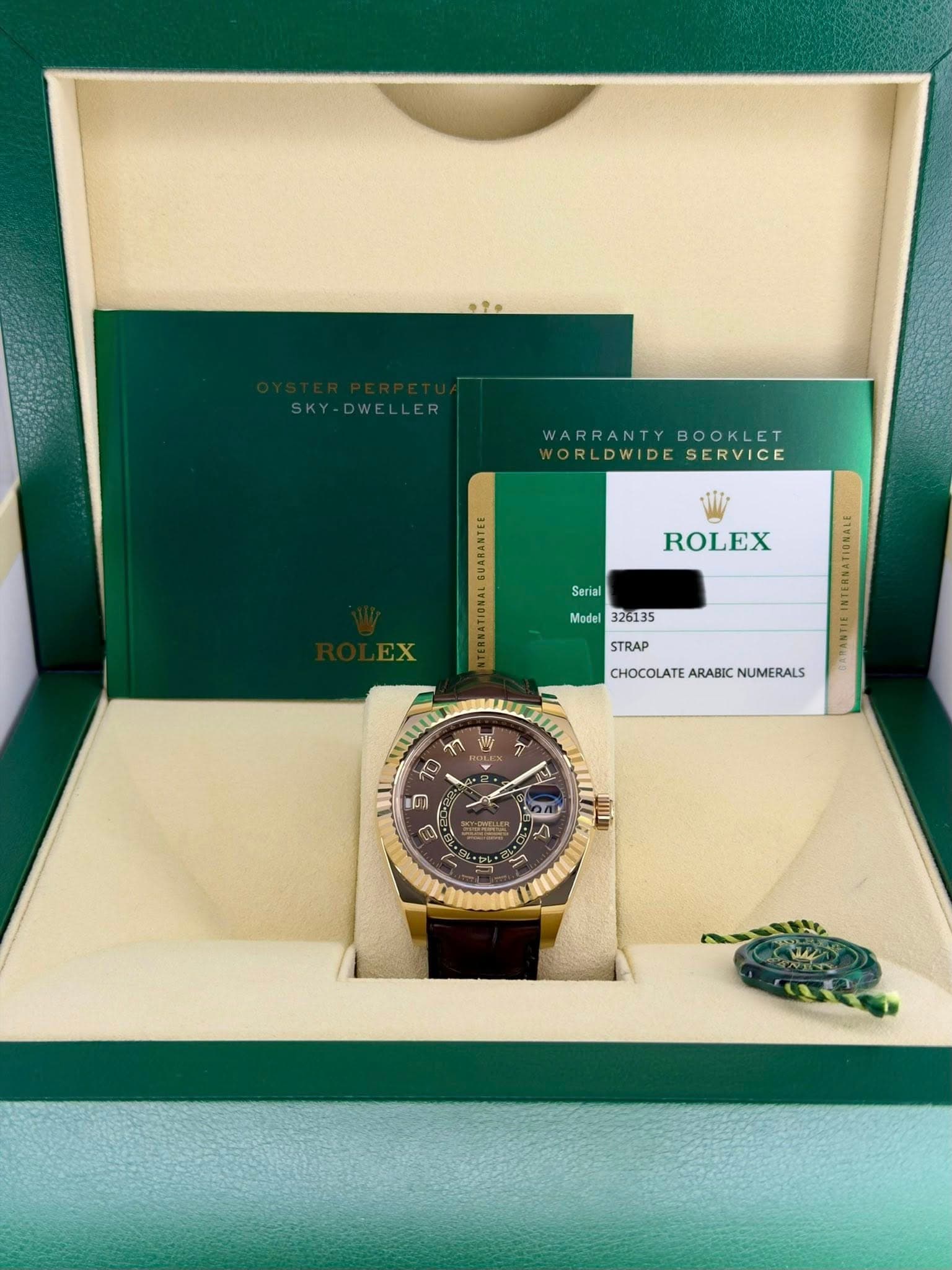 May be an image of wrist watch and text that says 'SKY-DWELLER WARRANTY BOOKLET WARRANTYBOOKLET T VORLDWIDESERVICE LDWIDE SERVICE ROLEX Serial Model 326135 STRAP CHOCOLATE/…