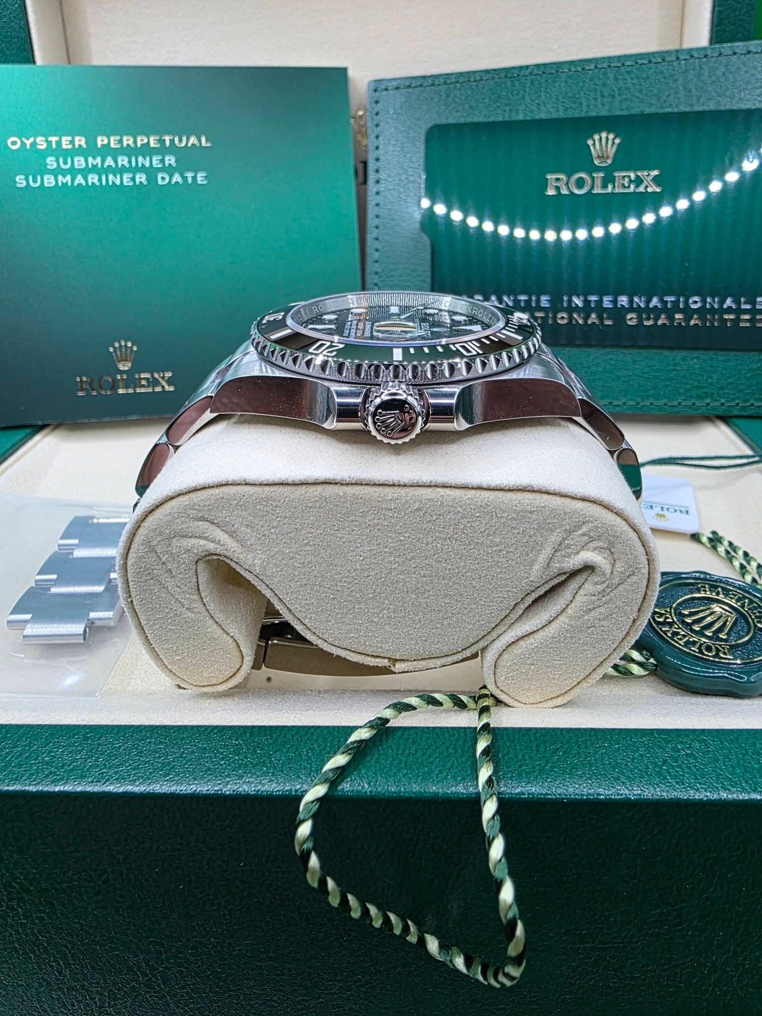 May be an image of text that says 'OYSTER OYSTERPERPETUAL PERPETUAL SUBMARINER SUBMARINER DATE ROLEX ROL INTERNATIONAL GUARRNTE F1OH തുുും'