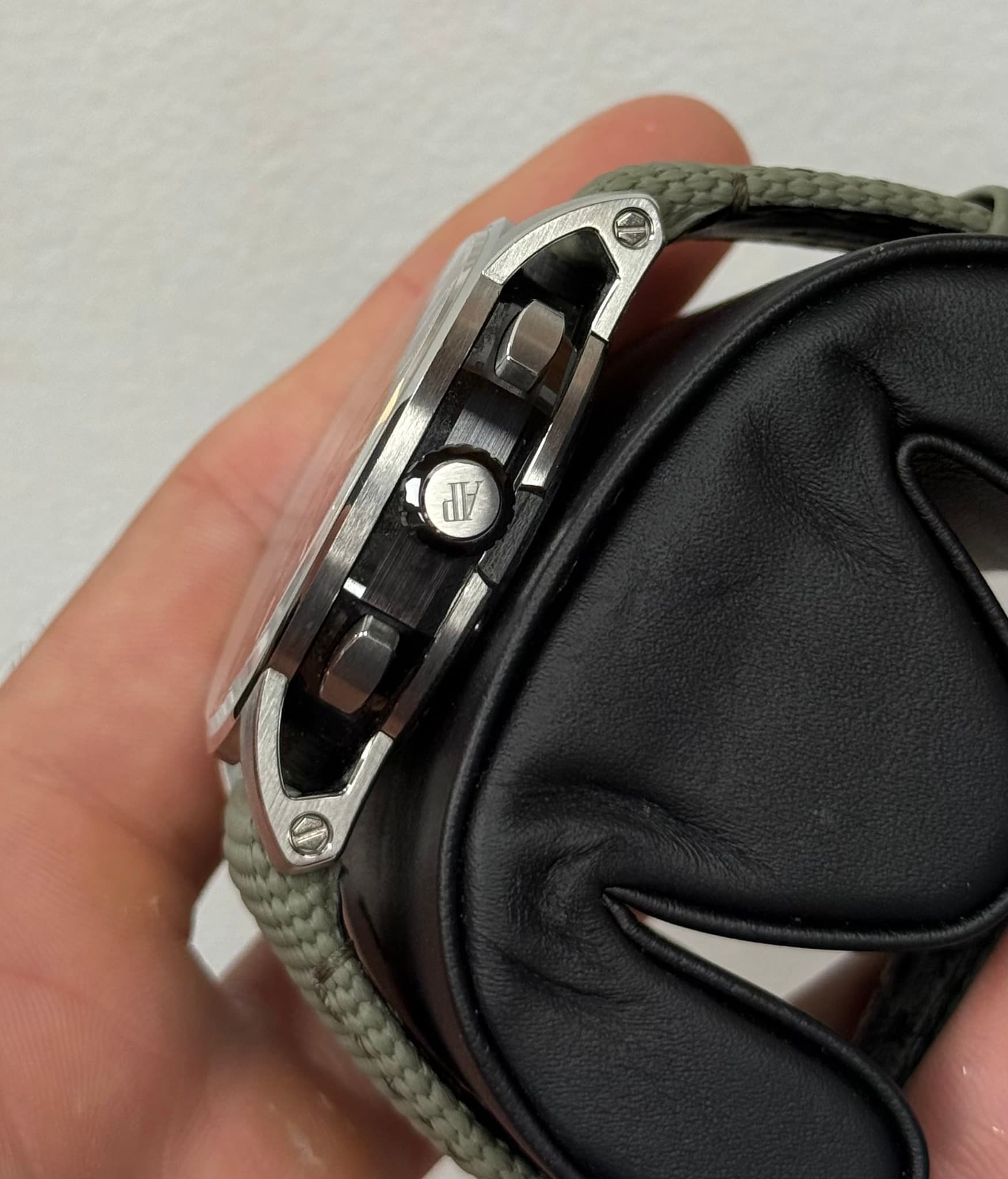 May be an image of wrist watch, leather wallet, lighter and saddle-stitched leather