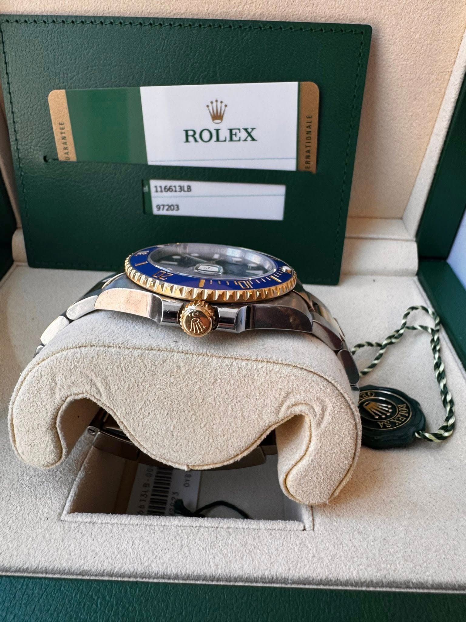 May be an image of wrist watch and text that says 'ARANTEE ROLEX 116613LB 97203'