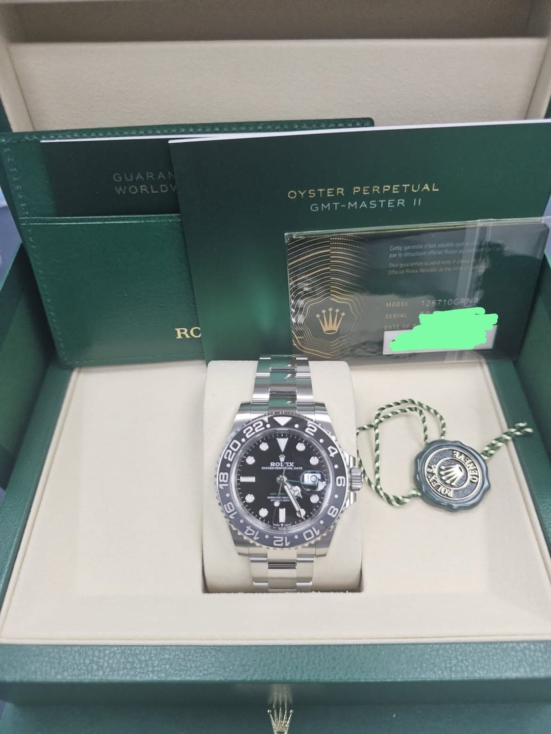 May be an image of wrist watch and text that says 'OYSTER YSTERPERPETUAL PERPETUAL GM1 GMT-MASTER| I1 RC SERIAL 126710GRNR 2 4 ROLEX ROL 10 ب 6 TI Ti'