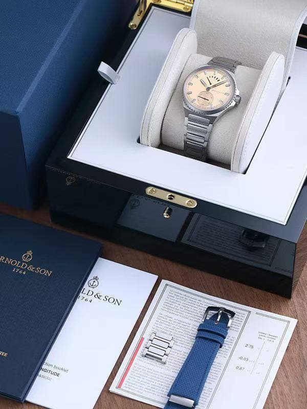 May be an image of wrist watch and text that says '0 " U N 0 導 NOLD&SON RNOLD& 1764 NOLD&SON &SON 1764 LD&SON LD&SON &SON EE NGITUDE booklet 596302 SSAMUDE Acirupeot ction Cy ጀንንላታ…