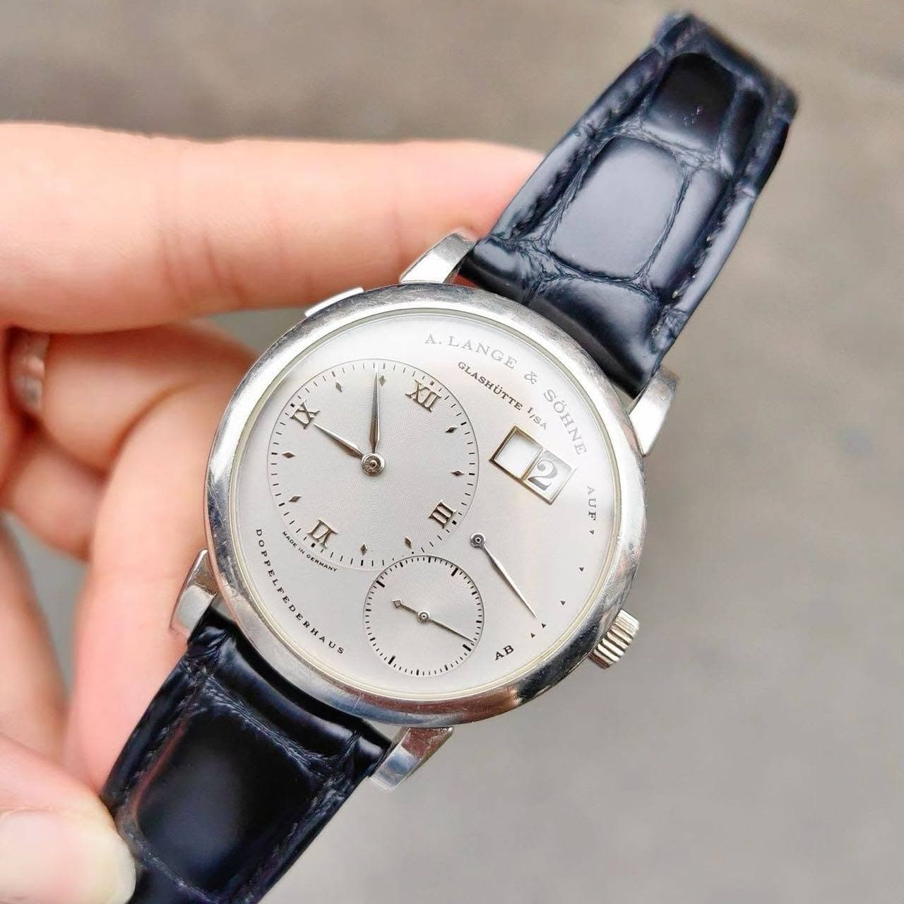 May be an image of wrist watch and text that says 'IX @ LANGE XLI LASHUTTI de LISA VIs SOHNE E AUIF o H a E US AB'