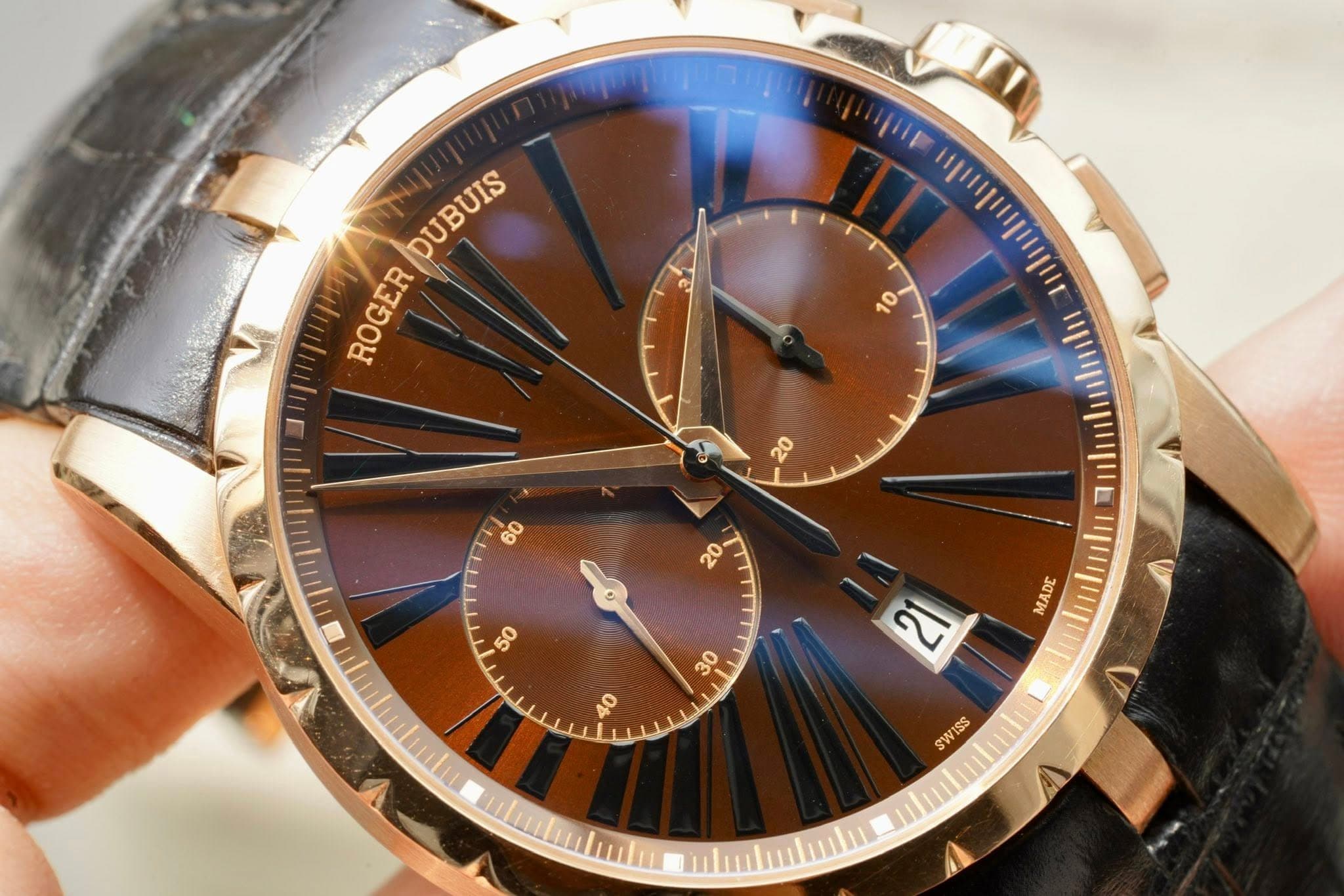 May be an image of wrist watch and text that says 'DUBUIS ROGER A0 2 MADE mbinlitu V SWISS'