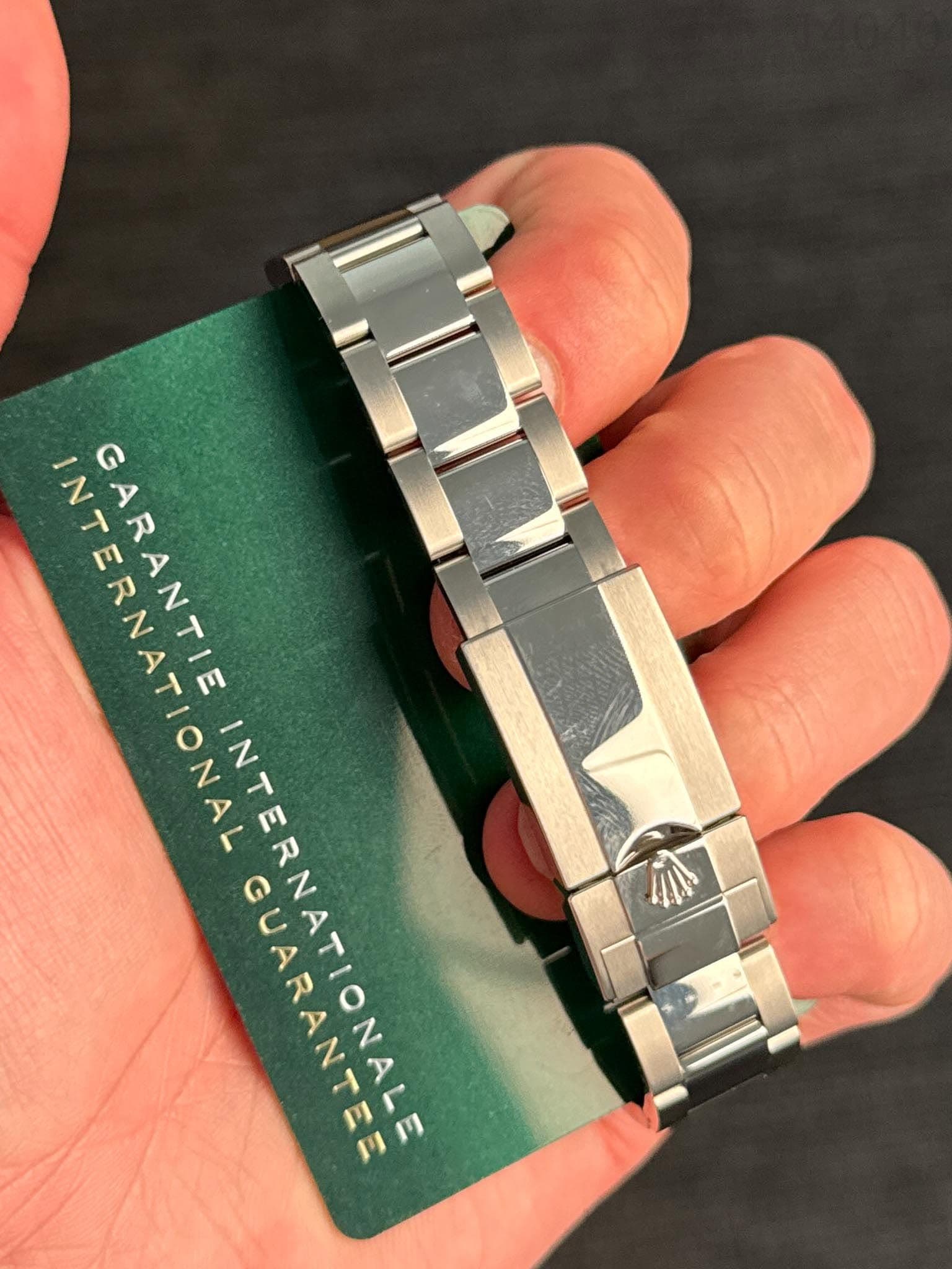 May be an image of wrist watch and text that says 'INTERNATIONA e RNATIONAL GARANTIE INTERNATIONALE INTERNATION GUARANTEE'