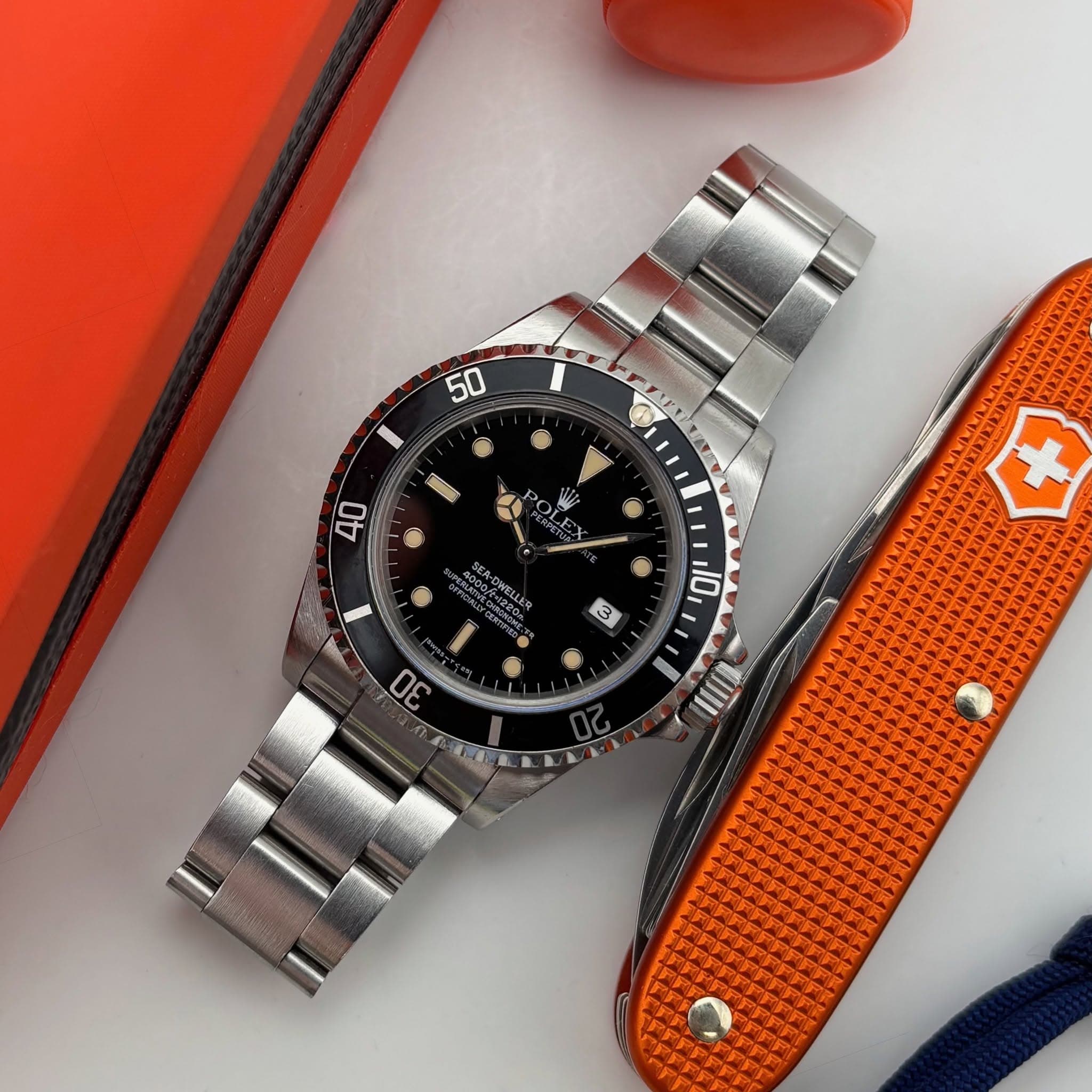May be an image of wrist watch, knife and text