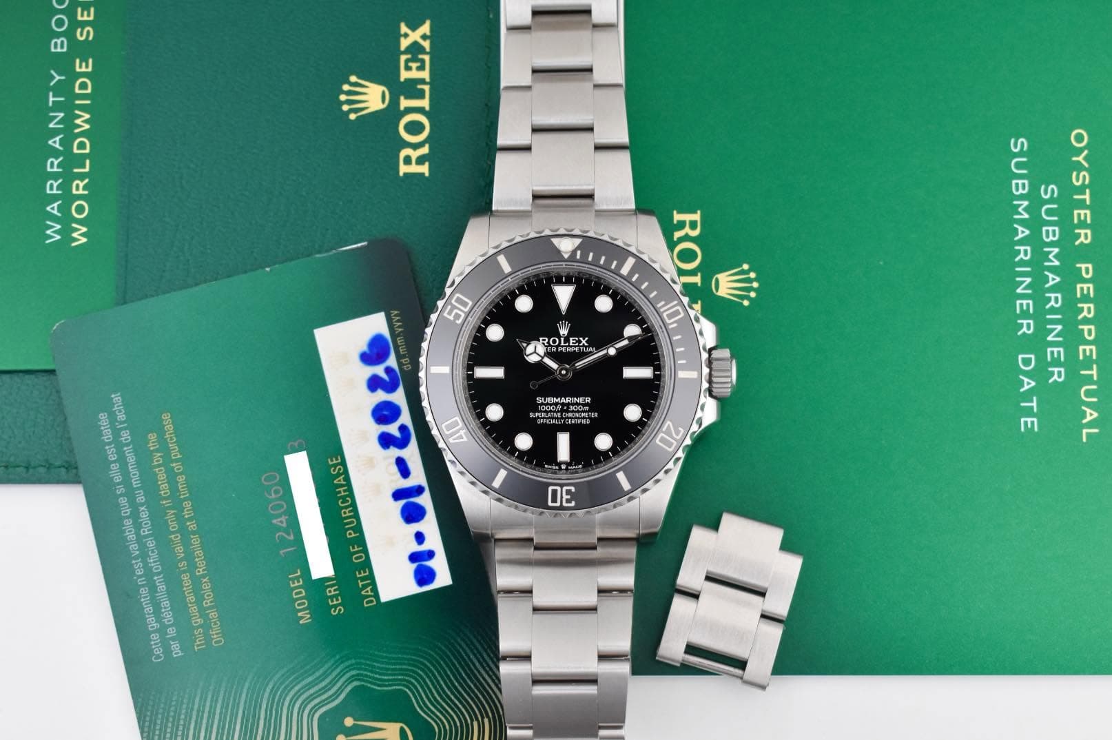 May be an image of wrist watch and text that says 'E 8 WARRANTY WORLDWIDE W ROLEX ROLEX RO 也 10 LTI 20 SUEMARINER ATECOOM datée de moment umen purchase achat est time dUe uB…