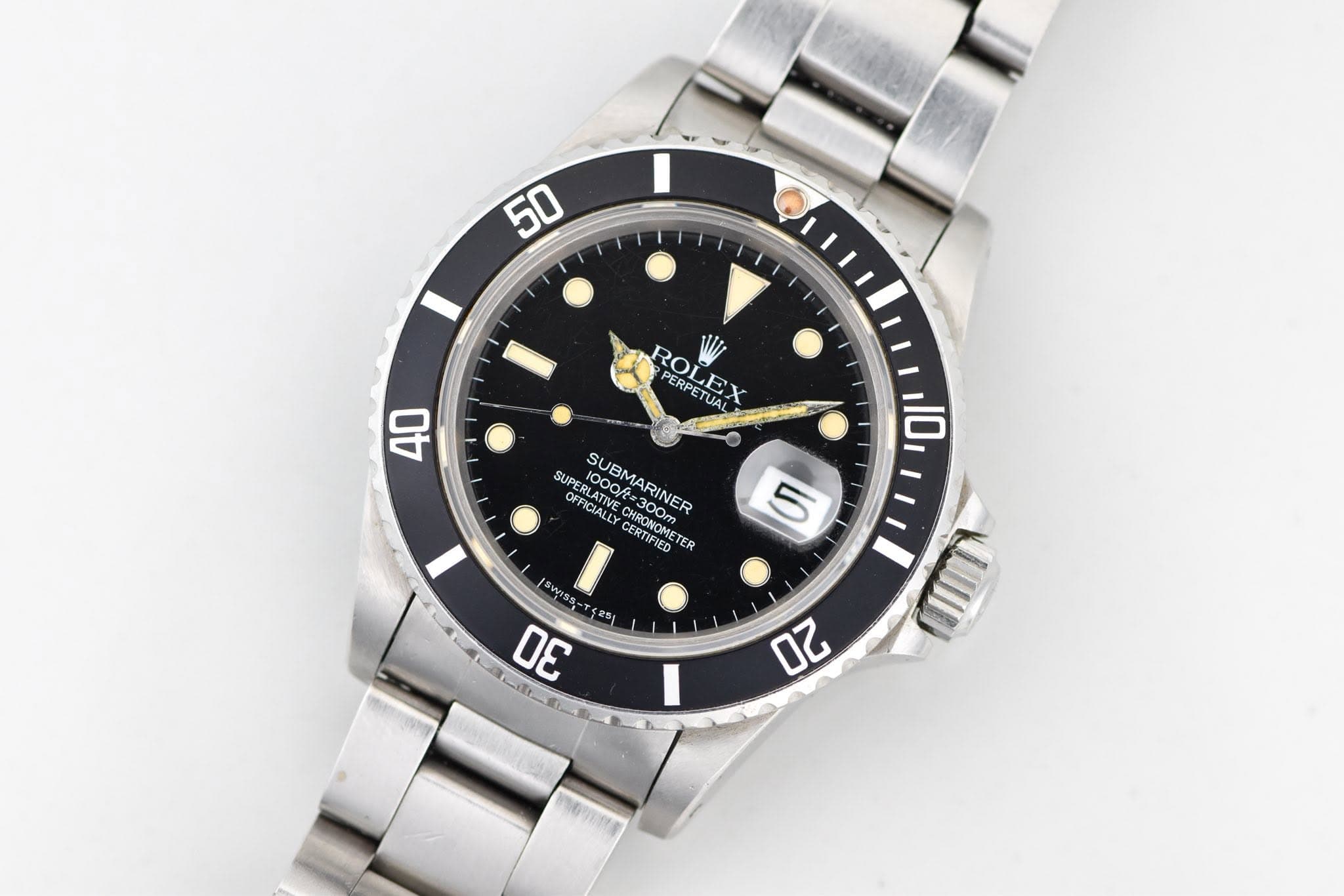 May be an image of wrist watch and text that says '50 ROLEX PERPE PERPETUA 40 10 SUPE PERLATIVE UPERLATAA 10004 SUBMARINER OESATVE FICIALEY FFICIALLY 1000/ SUBMARINES OOOARINER…