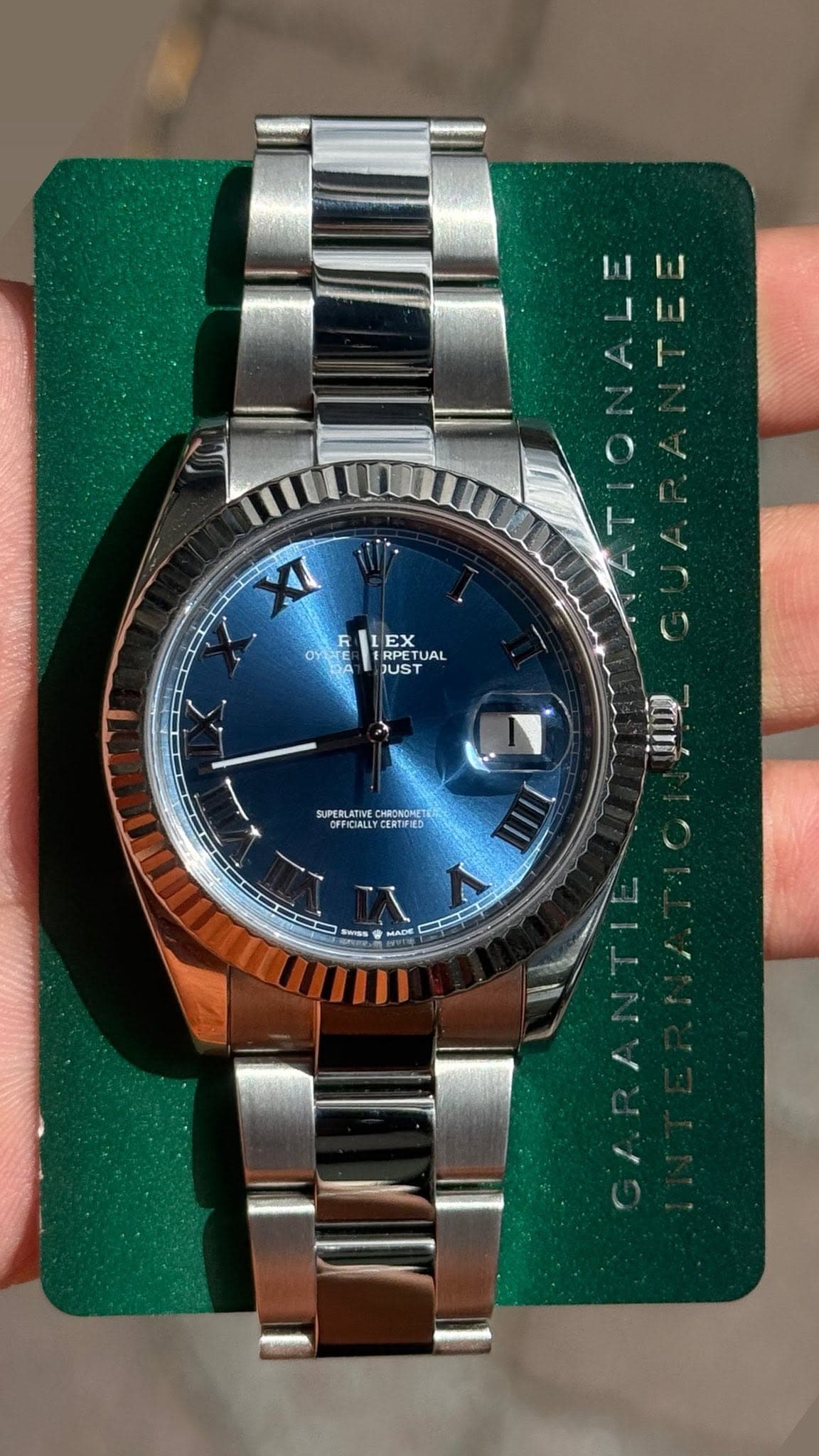 May be an image of wrist watch and text that says 'EX RPETUAL TUAL JUST SUPERLATIVE OFFICIALEY CEИTPИ3 சியர்'