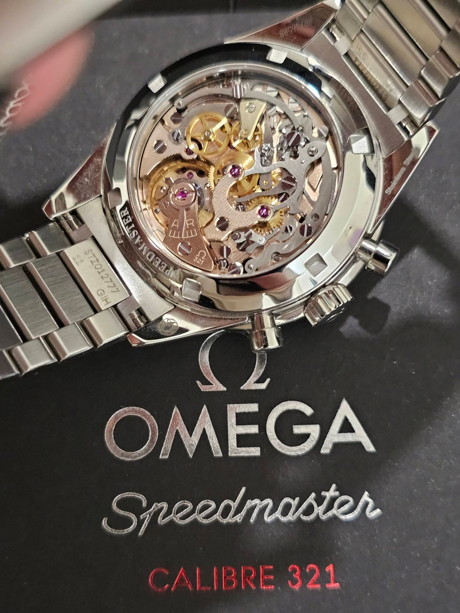 May be an image of wrist watch and text that says 'SETE 糖 g waaa STZ012777 RERSAREEERE 茶 GIH AUME OMEGA Speedmaster CAL CALIBRE.321 IBRE 321'