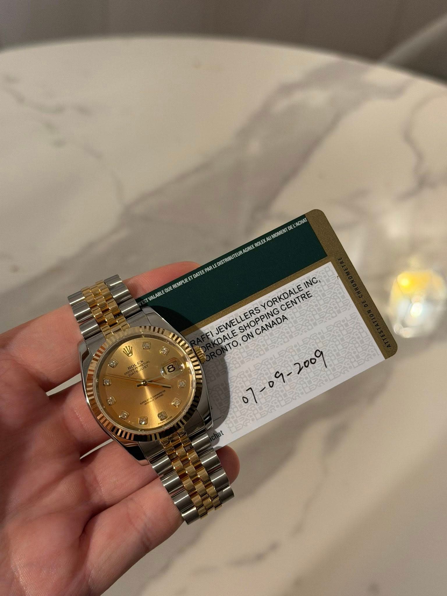 May be an image of wrist watch and text that says 'ACHAZ MOMIENT RGLEX PAR 無都 DISTRIBU AΑTE VALABL EQU QUE REMPLE YORKDALE INC, CENTRE JEWELLERS SHOPPING CHO FI DALE DALE To, ON…
