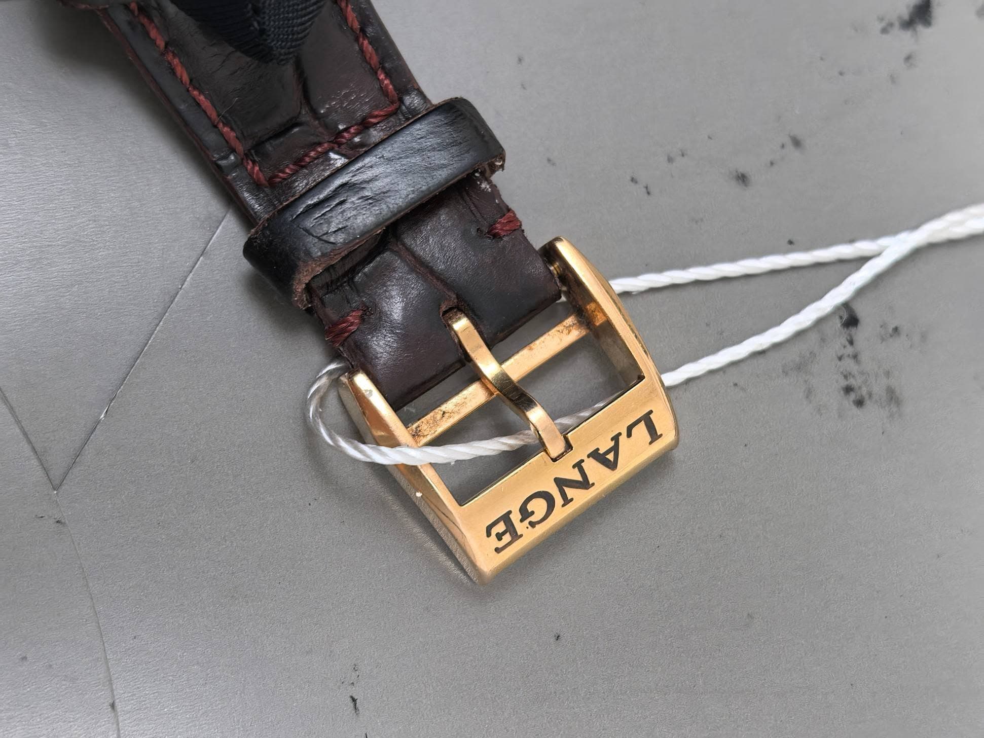 May be an image of wrist watch, leather, saddle-stitched leather and text