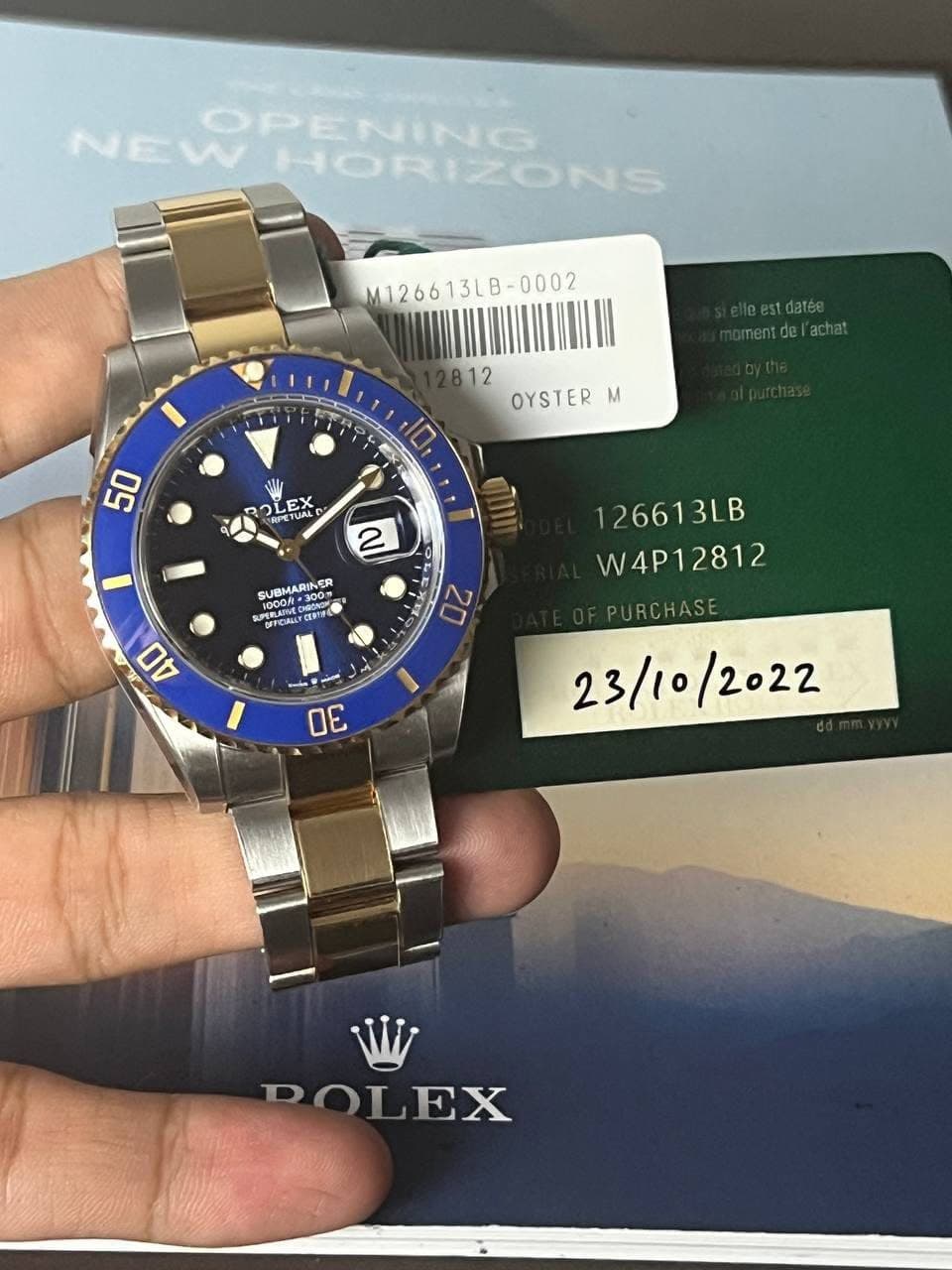 May be an image of wrist watch and text that says 'NEW NEWPENING HORIZONS OPENING M126613LB-0002 mentdelachat 12 OYSTER M 50 LEX E EX AL » ぼませる SUNO SUBMARINER INER SPERLAIN 1000f-…