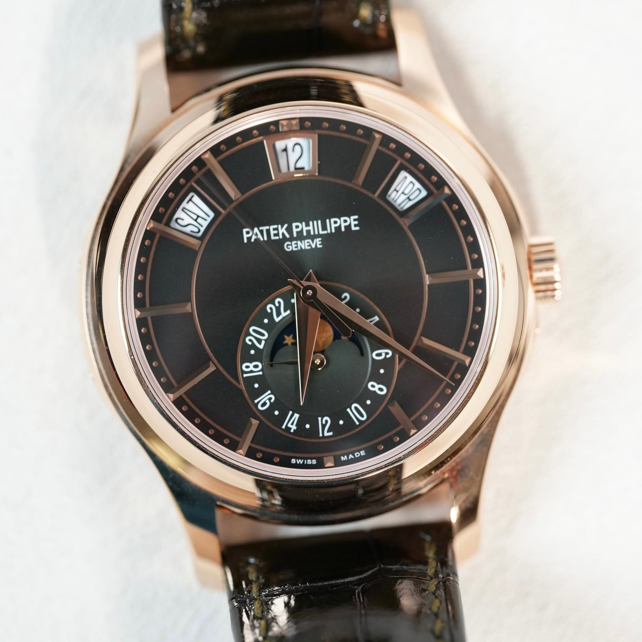 May be an image of wrist watch and text that says '12 क APD PATEK PHILIPPE GENEVE SWIS8 MADE'