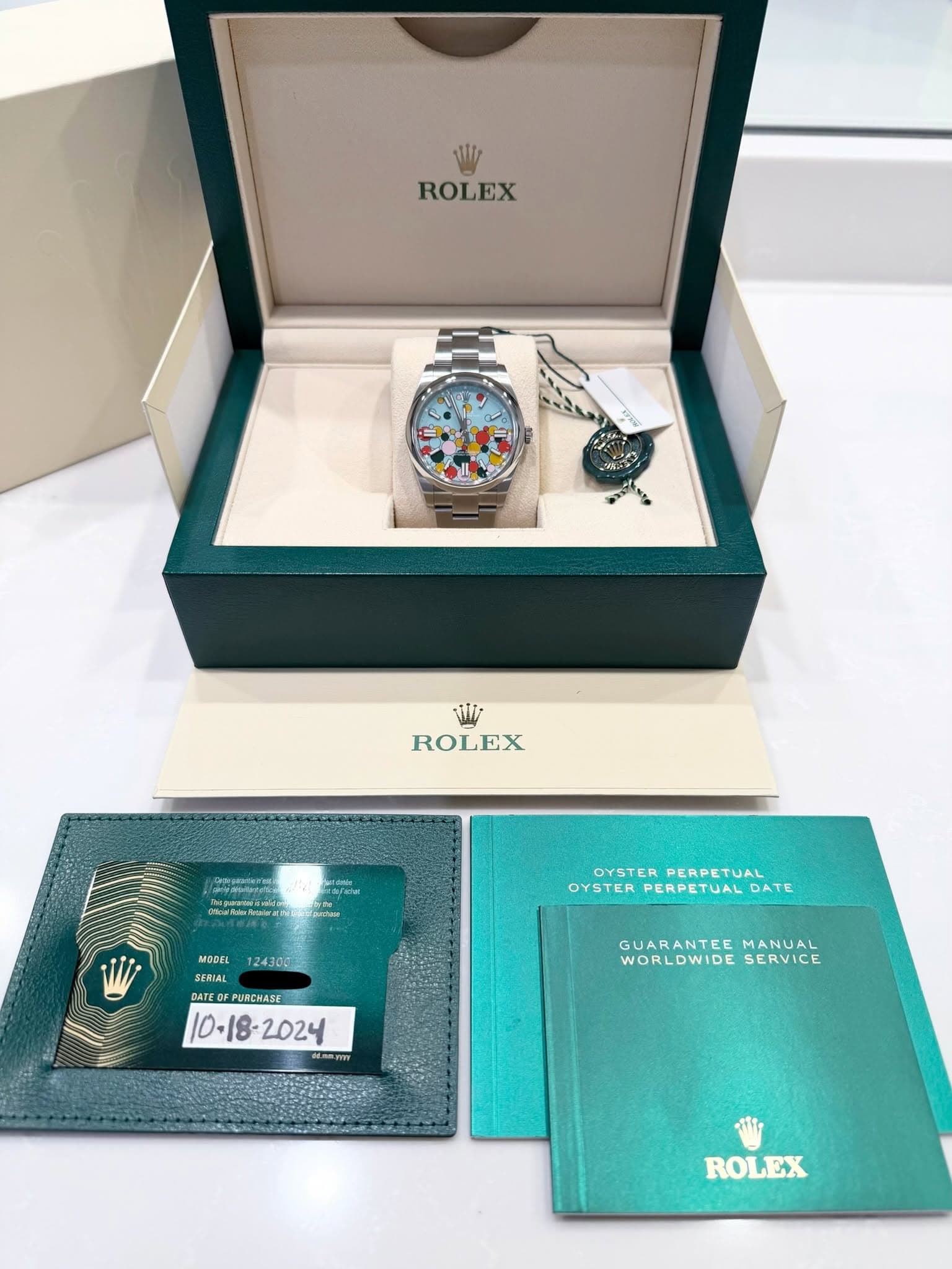 May be an image of wrist watch and text that says 'ROLEX Vi ROLEX EX はめたーい ดทียลส 124300 OYSTER OYSTERPERPETUAL PERPETUAL OYSTER PERPETUAL OYSTERPERPETUALDATE JAL DATE MODEL SERTAL…