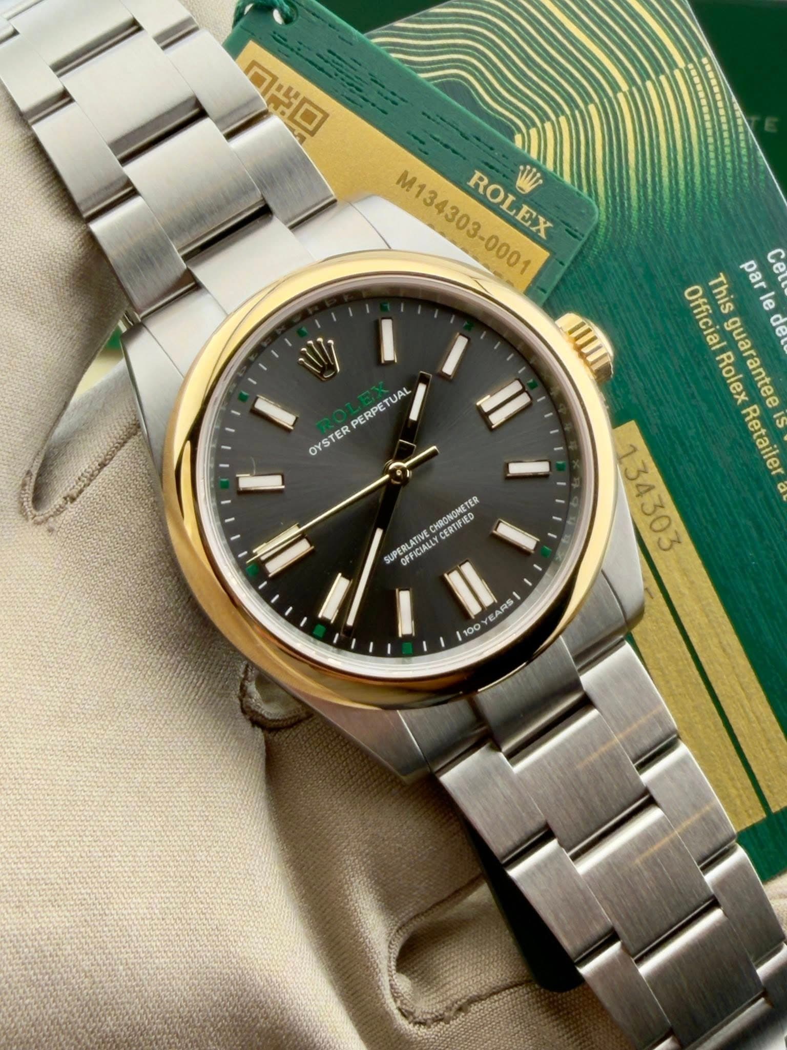 May be an image of wrist watch and text that says 'סים 0治口 M134303-000 ROLEX EX IIII M V UAL PERPE OYS OYSTER TER Officia Rolex guarantee de This par Ceb le 134303 Retaile…